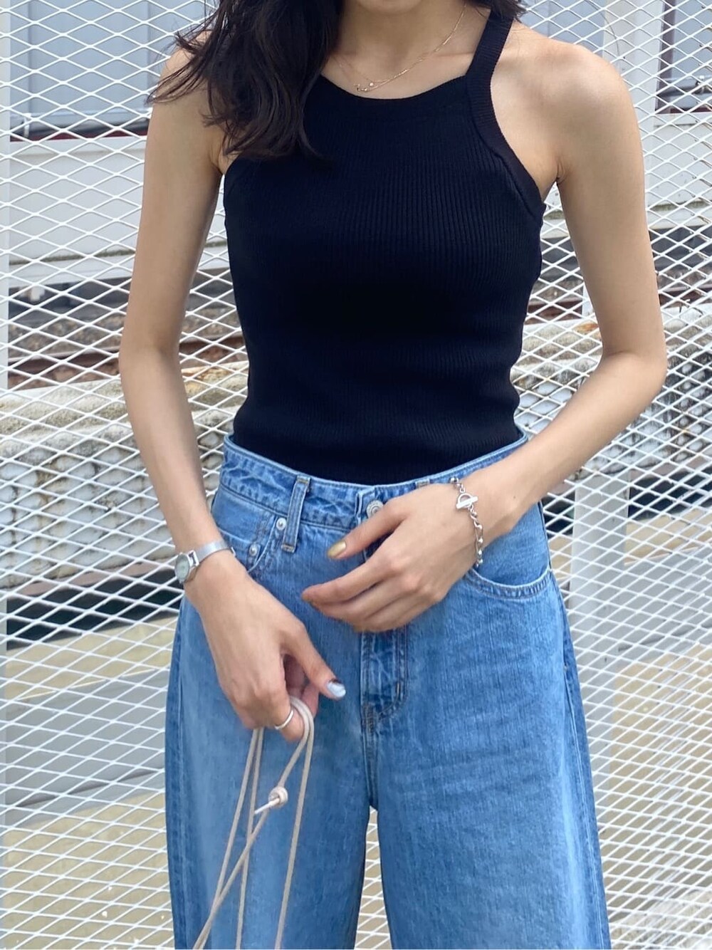 ブラック系のサンダル、ブルー系のハンドバッグ、ブラック系のタンクトップを着用したレディースの夏コーディネートの5枚目の写真