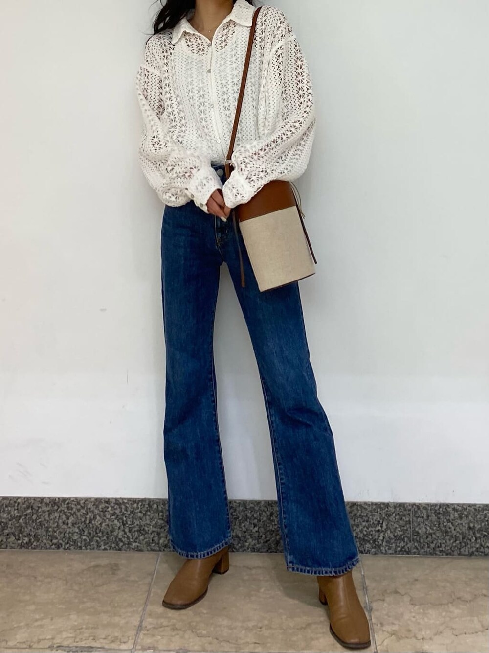 ブラウン系のショルダーバッグ、ブルー系のデニムパンツ、ホワイト系のシャツ/ブラウスを着用したレディースの春コーディネートの2枚目の写真