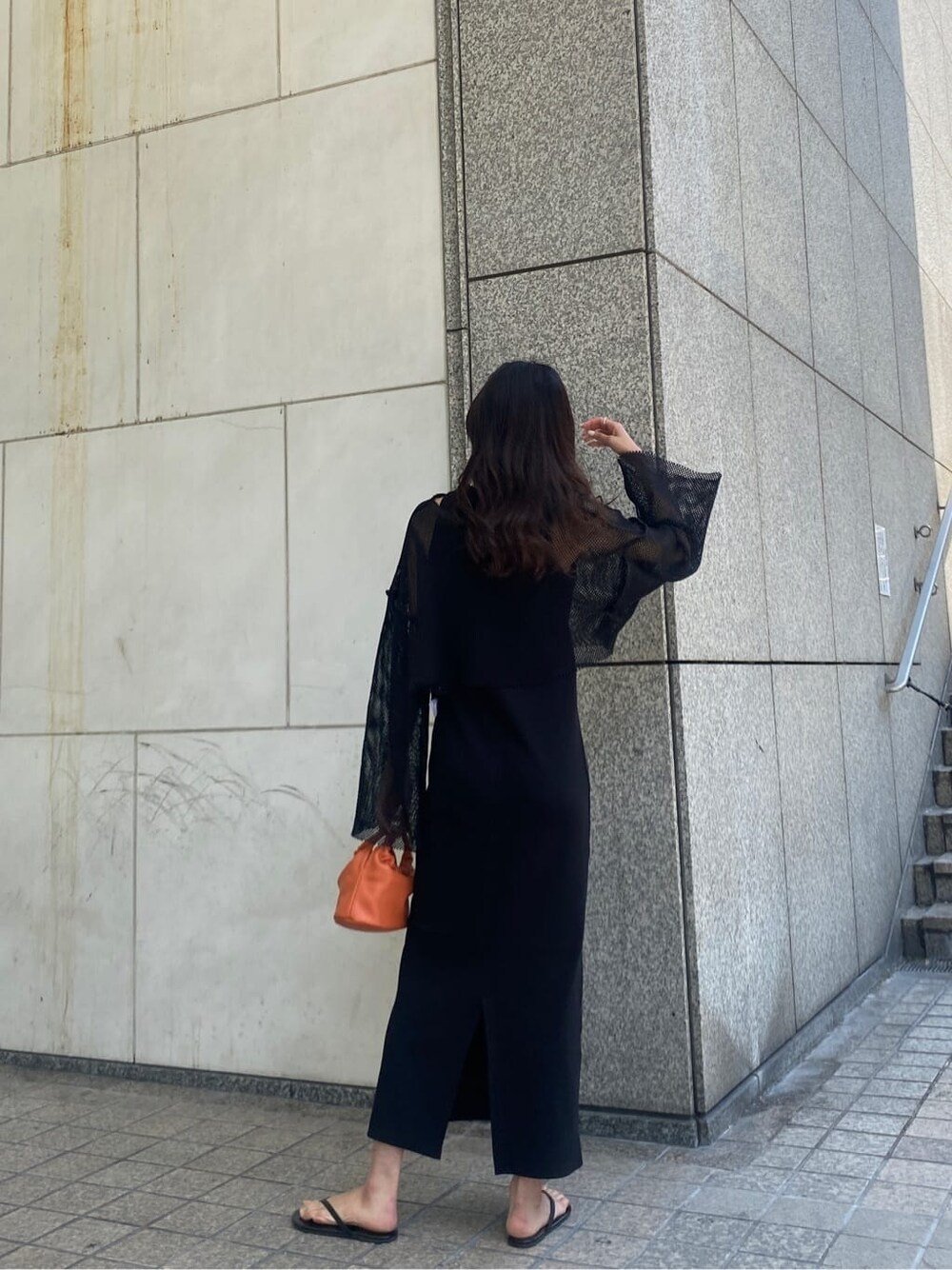 ブラック系のTシャツ/カットソー、ブラック系のワンピース、オレンジ系のハンドバッグを着用したレディースの春コーディネートの3枚目の写真