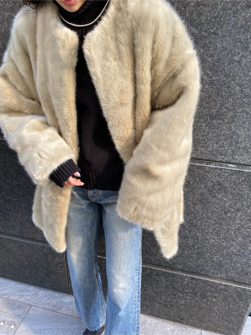 グレー系のその他アウター、ブルー系のデニムパンツ、ブラック系のニット/セーターを着用したレディースの冬コーディネートの4枚目の写真