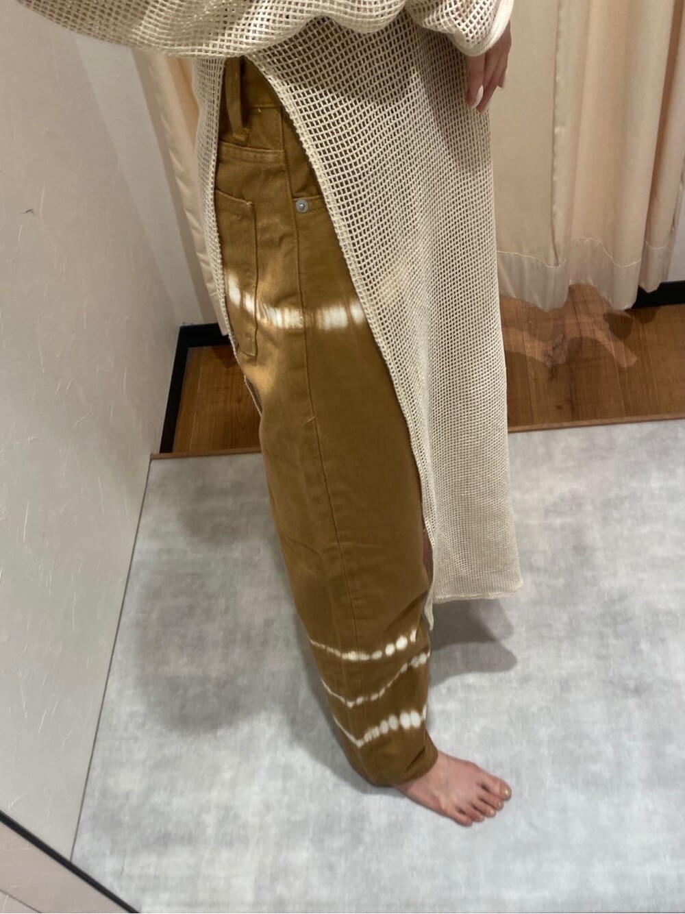 ホワイト系のワンピース、ブラウン系のデニムパンツを着用したレディースの春コーディネートの5枚目の写真