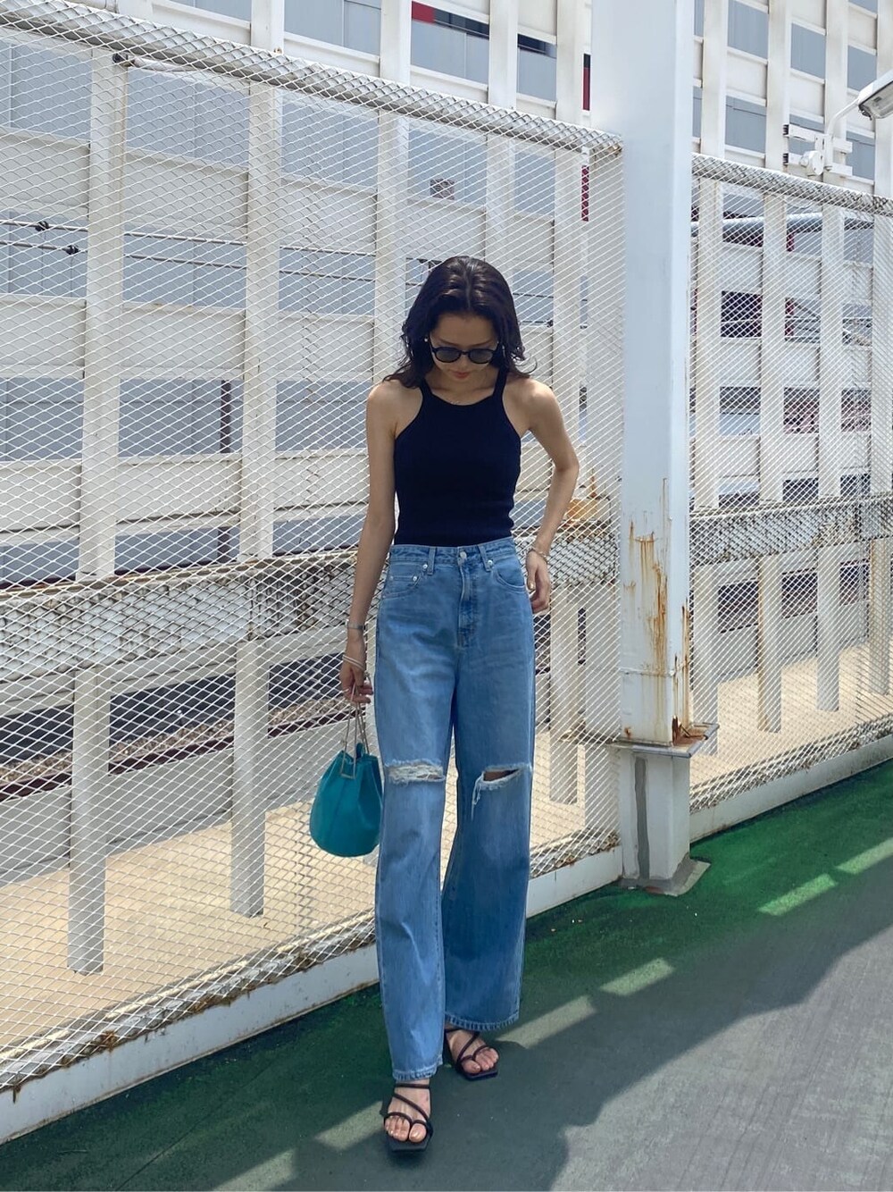 ブラック系のサンダル、ブルー系のハンドバッグ、ブラック系のタンクトップを着用したレディースの夏コーディネートの3枚目の写真