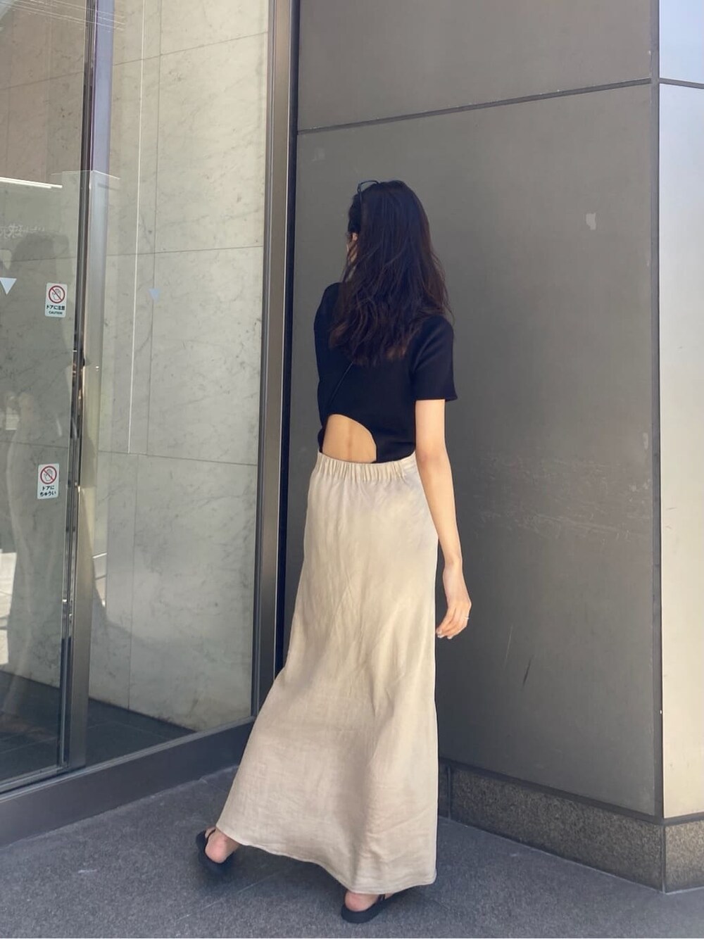ベージュ系のスカート、ブラック系のTシャツ/カットソーを着用したレディースの夏コーディネートの3枚目の写真