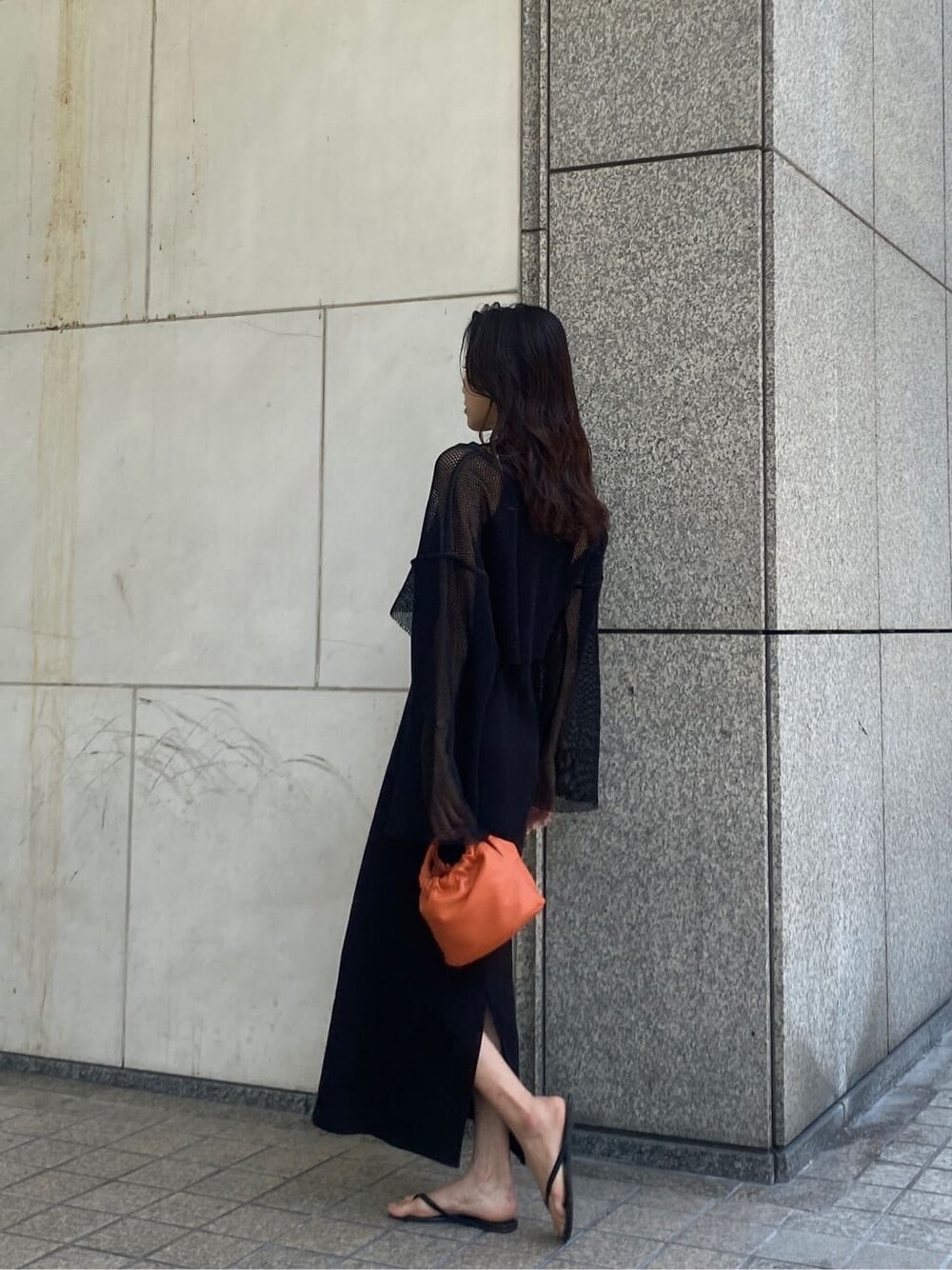 ブラック系のTシャツ/カットソー、ブラック系のワンピース、オレンジ系のハンドバッグを着用したレディースの春コーディネートの4枚目の写真