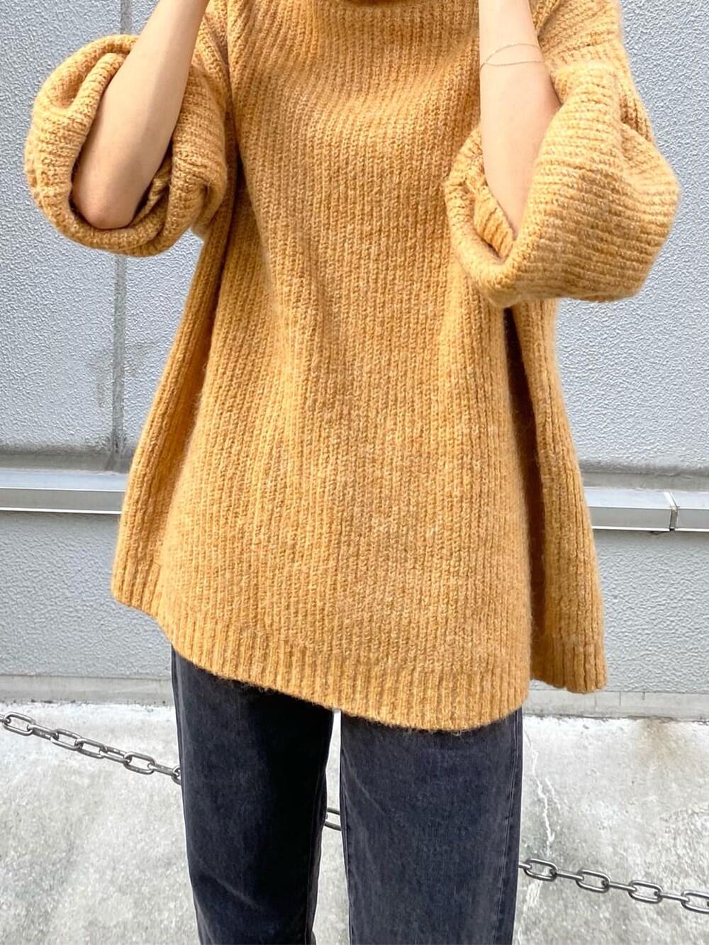 ブラック系のデニムパンツ、イエロー系のニット/セーターを着用したレディースの秋コーディネートの6枚目の写真