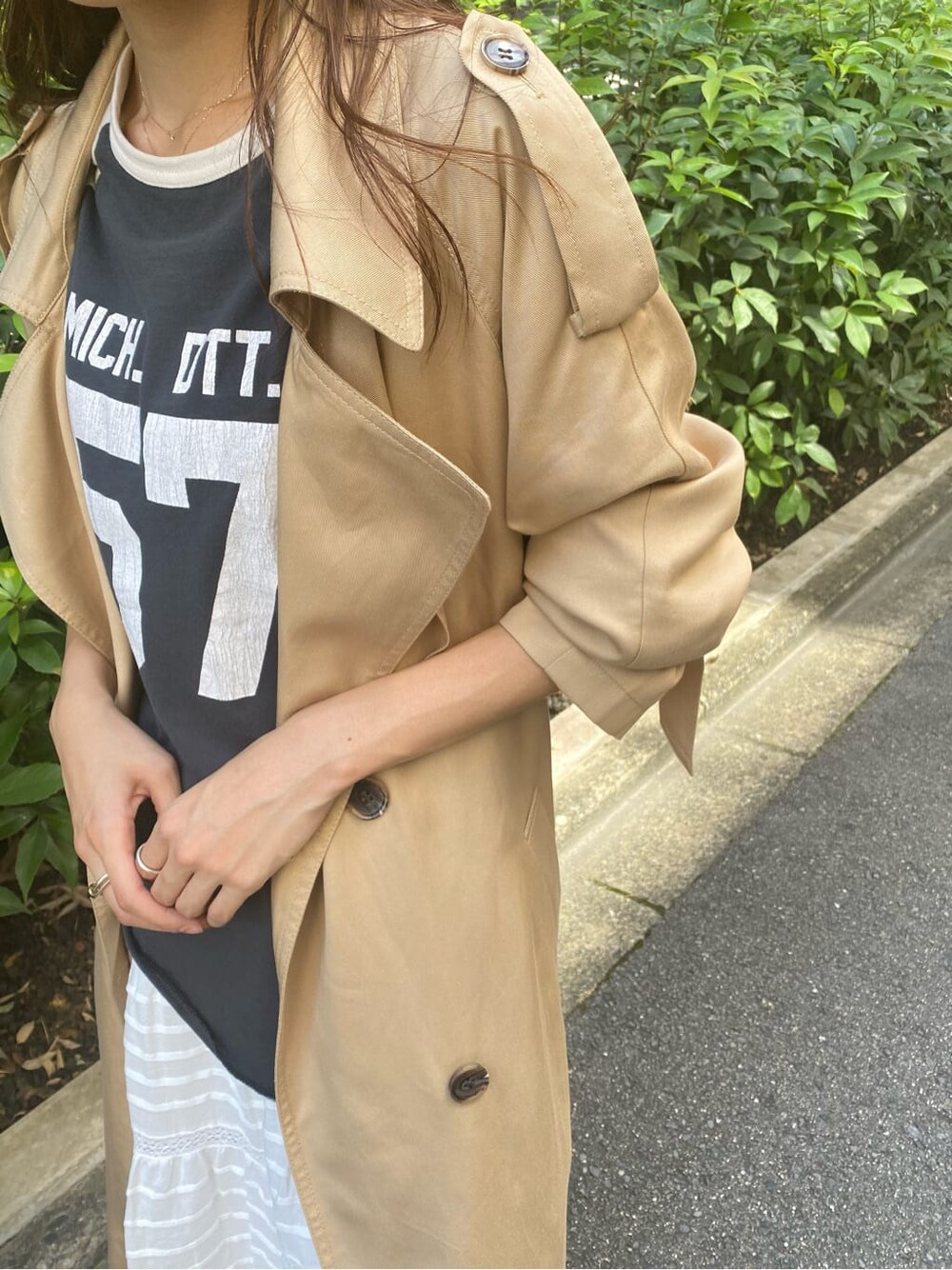 ベージュ系のトレンチコート、ホワイト系のスカート、グレー系のTシャツ/カットソーを着用したレディースの夏コーディネートの6枚目の写真