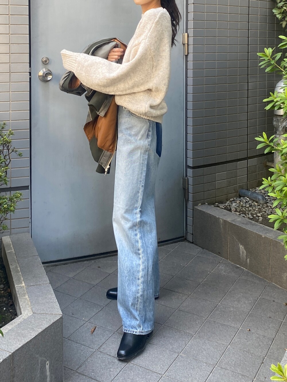 ホワイト系のニット/セーター、ブルー系のデニムパンツ、ブラック系のブーツを着用したレディースの秋コーディネートの4枚目の写真