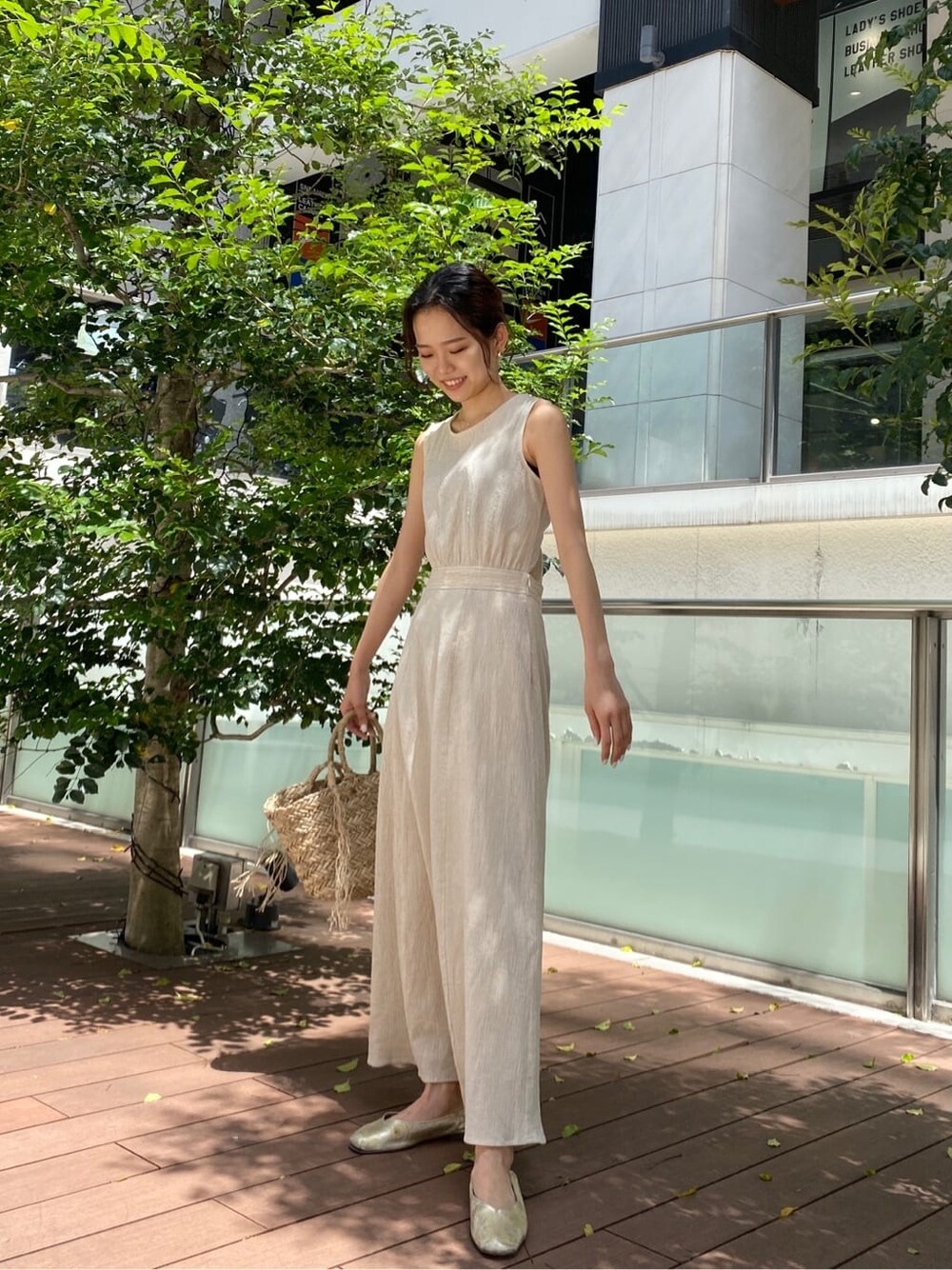 ベージュ系のかごバッグ、ホワイト系のワンピースを着用したレディースの春コーディネートの2枚目の写真