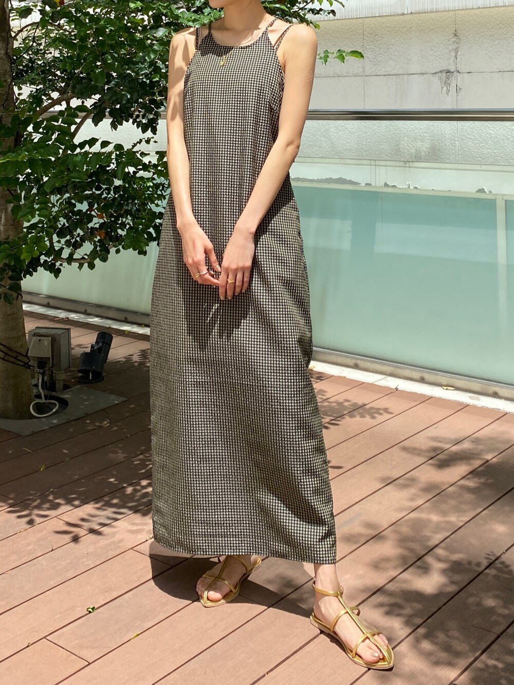 ベージュ系のワンピース、ゴールド系のサンダルを着用したレディースの春コーディネートの2枚目の写真