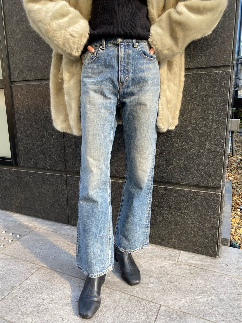 グレー系のその他アウター、ブルー系のデニムパンツ、ブラック系のニット/セーターを着用したレディースの冬コーディネートの6枚目の写真