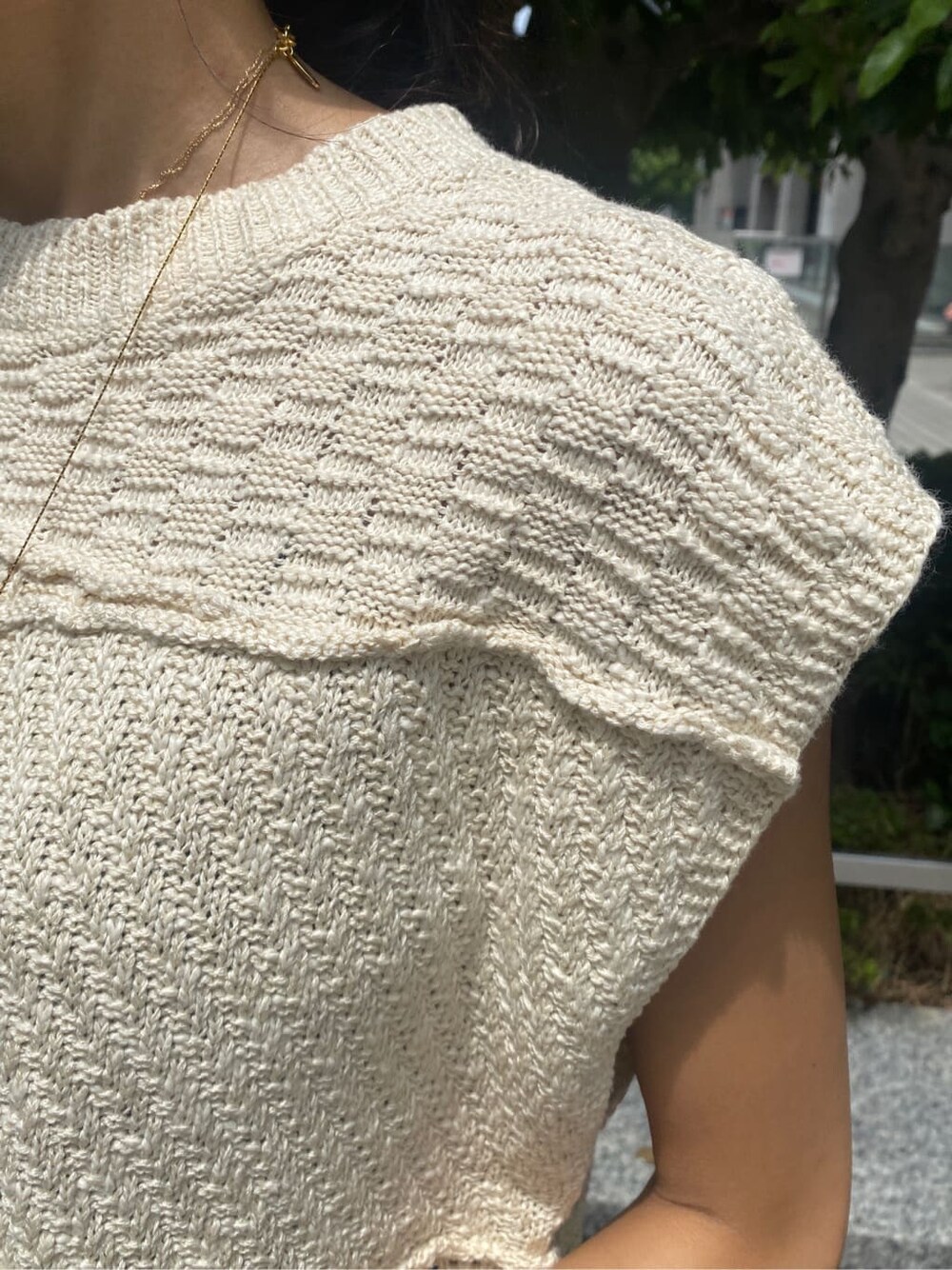 ホワイト系のスカート、ホワイト系のニット/セーター、ゴールド系のネックレスを着用したレディースの夏コーディネートの5枚目の写真