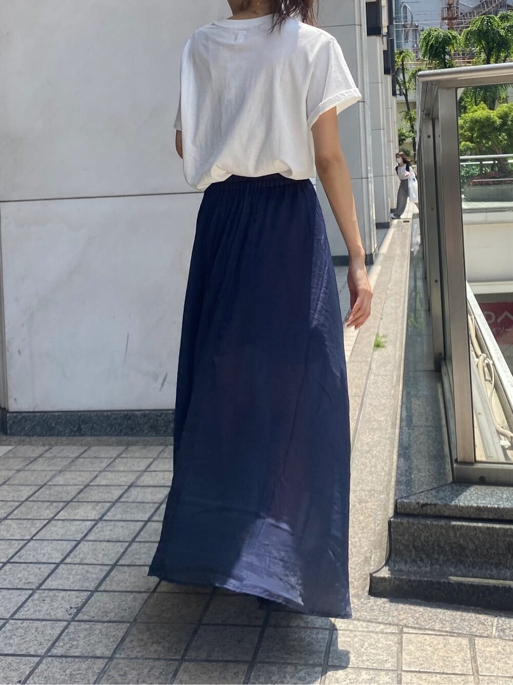 ホワイト系のTシャツ/カットソー、ブルー系のスカートを着用したレディースの春コーディネートの3枚目の写真