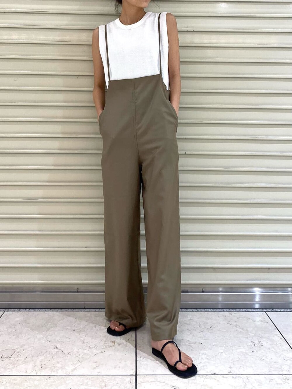 ホワイト系のタンクトップ、ベージュ系のつなぎ/オールインワン、ブラック系のサンダルを着用したレディースの夏コーディネートの2枚目の写真