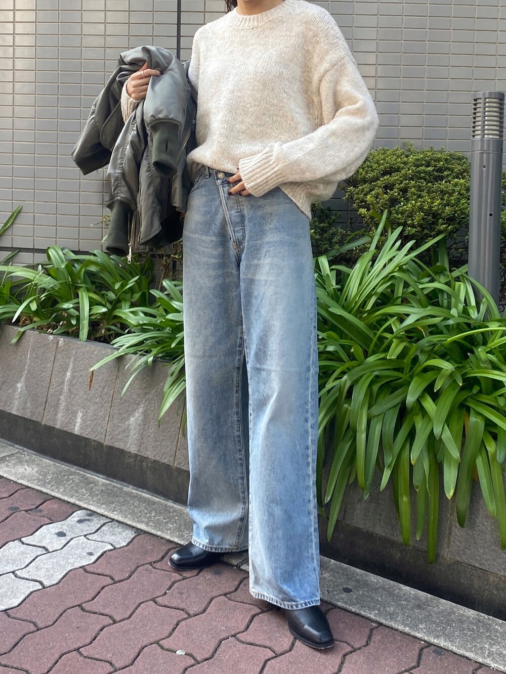 ホワイト系のニット/セーター、ブルー系のデニムパンツ、ブラック系のブーツを着用したレディースの秋コーディネートの2枚目の写真