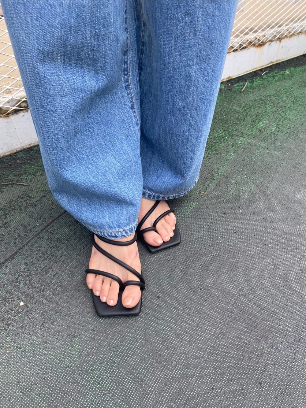 ブラック系のサンダル、ブルー系のハンドバッグ、ブラック系のタンクトップを着用したレディースの夏コーディネートの6枚目の写真