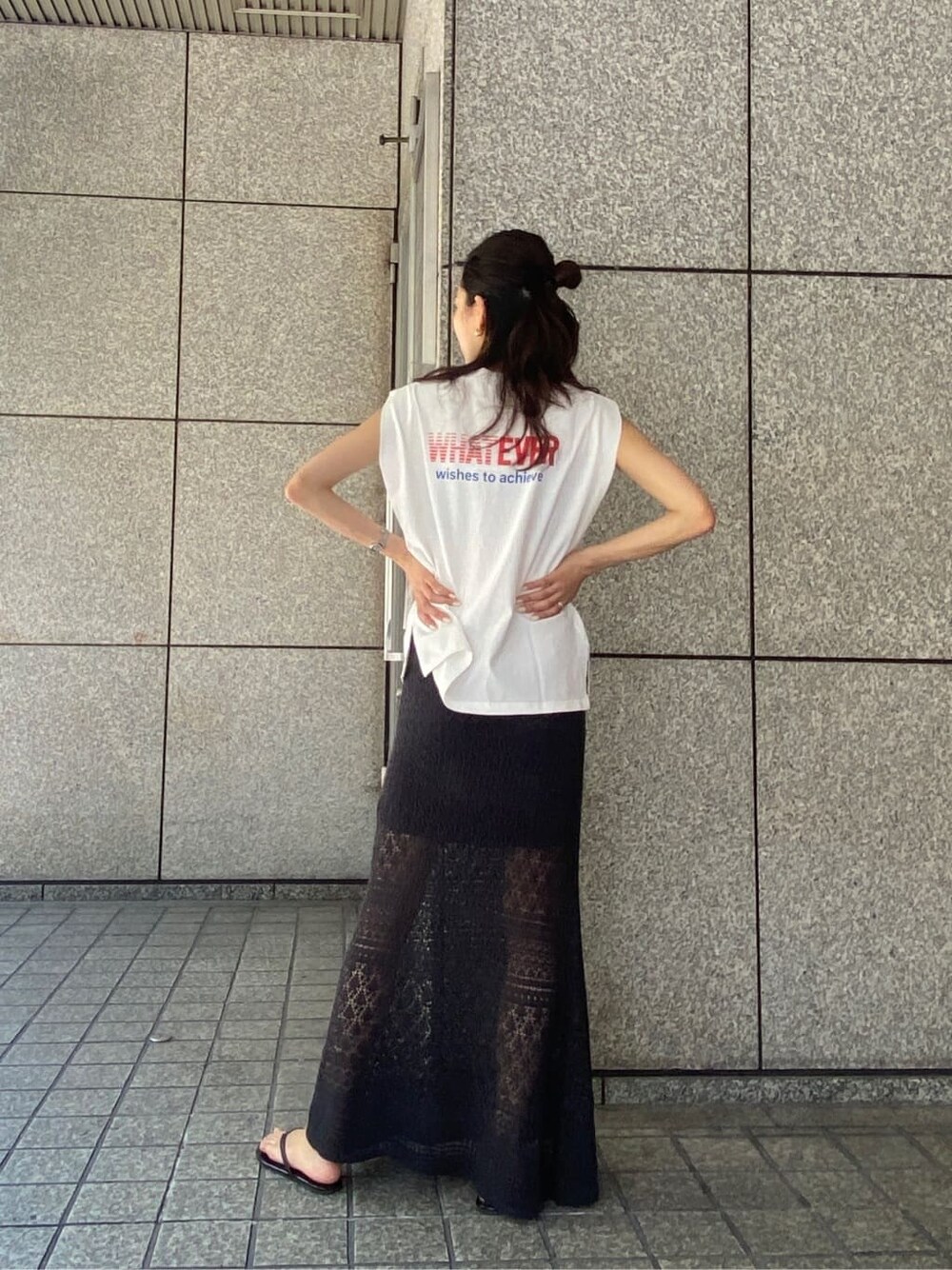 グレー系のスカート、ホワイト系のタンクトップ、シルバー系のネックレスを着用したレディースの春コーディネートの2枚目の写真