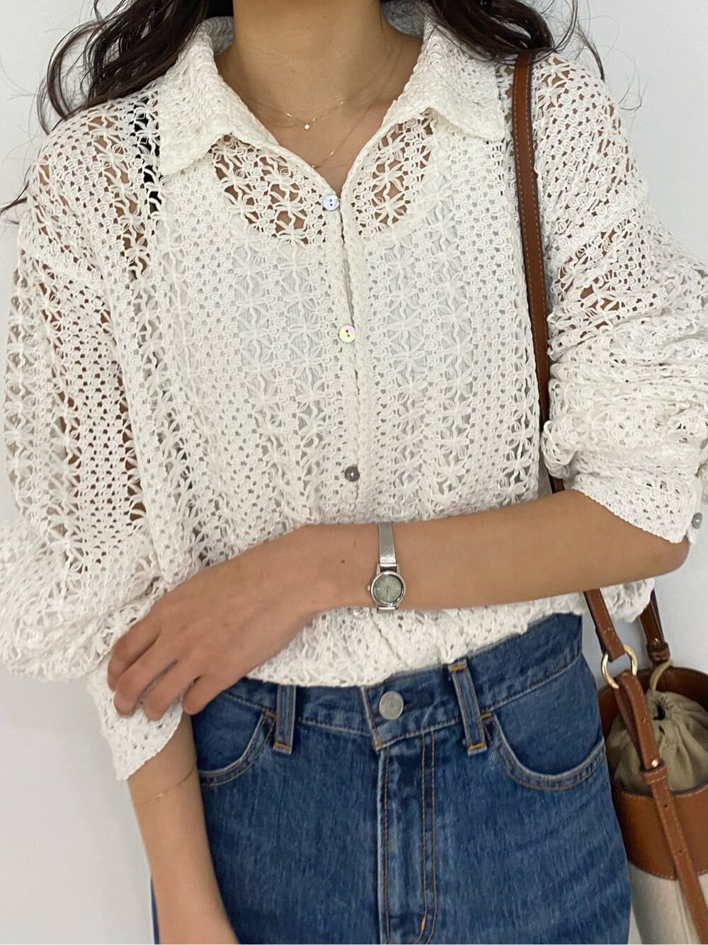 ブラウン系のショルダーバッグ、ブルー系のデニムパンツ、ホワイト系のシャツ/ブラウスを着用したレディースの春コーディネートの7枚目の写真