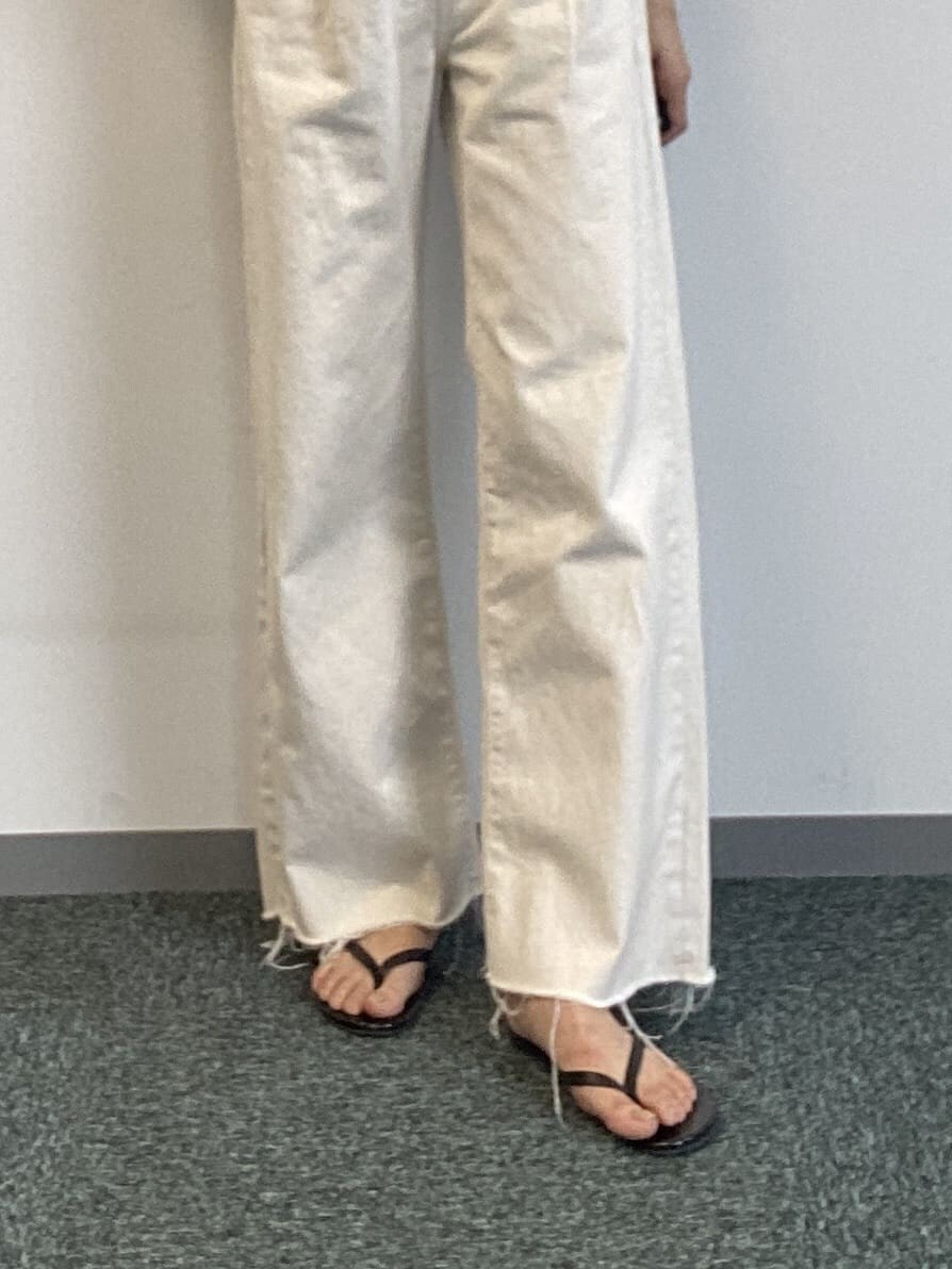 ホワイト系のデニムパンツ、グリーン系のニット/セーターを着用したレディースの春コーディネートの4枚目の写真