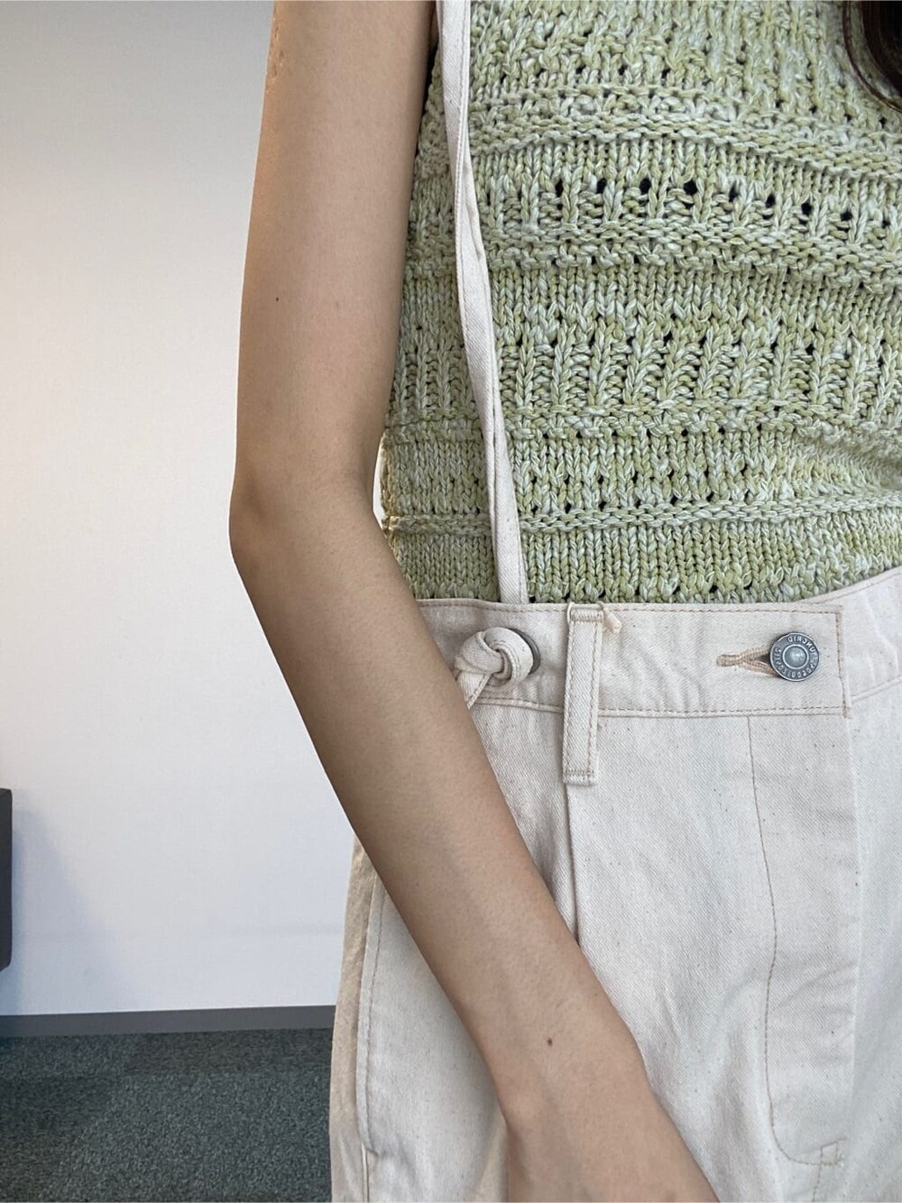 ホワイト系のデニムパンツ、グリーン系のニット/セーターを着用したレディースの春コーディネートの7枚目の写真