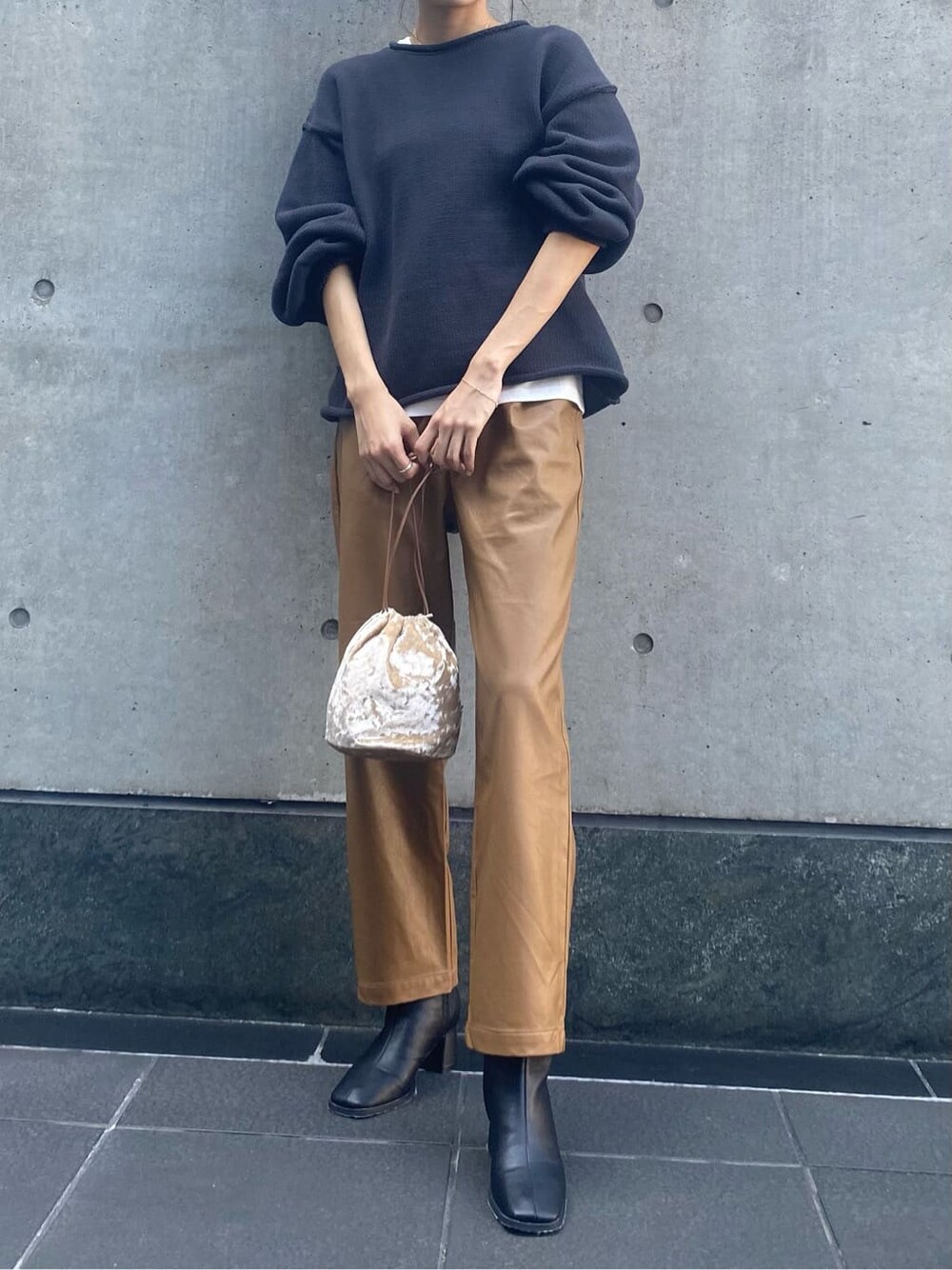 ブラウン系のその他パンツ、ブラック系のブーツ、ホワイト系のハンドバッグを着用したレディースの秋コーディネートの2枚目の写真