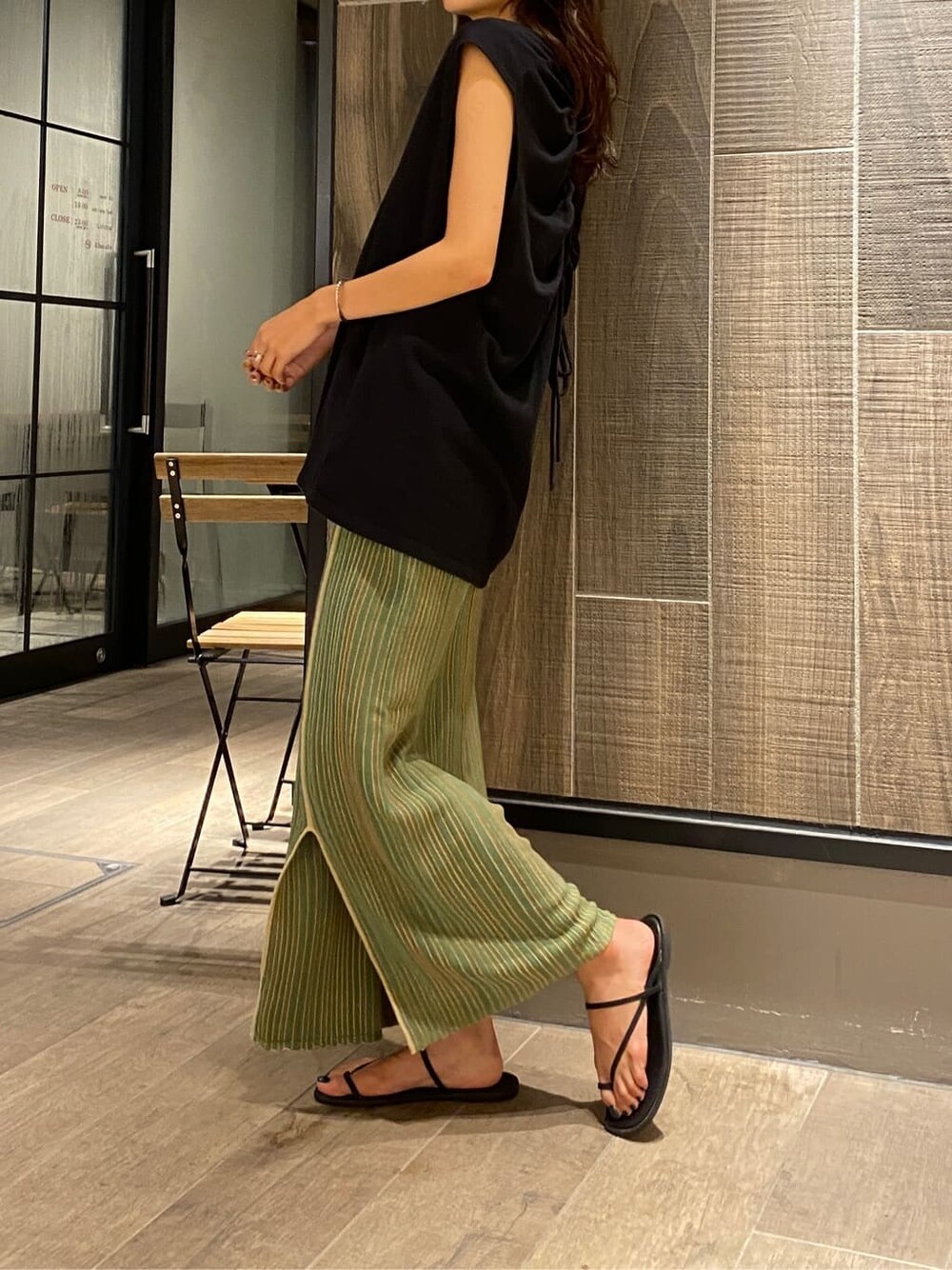 ブラック系のサンダル、ブラック系のTシャツ/カットソー、グリーン系のスカートを着用したレディースの夏コーディネートの3枚目の写真