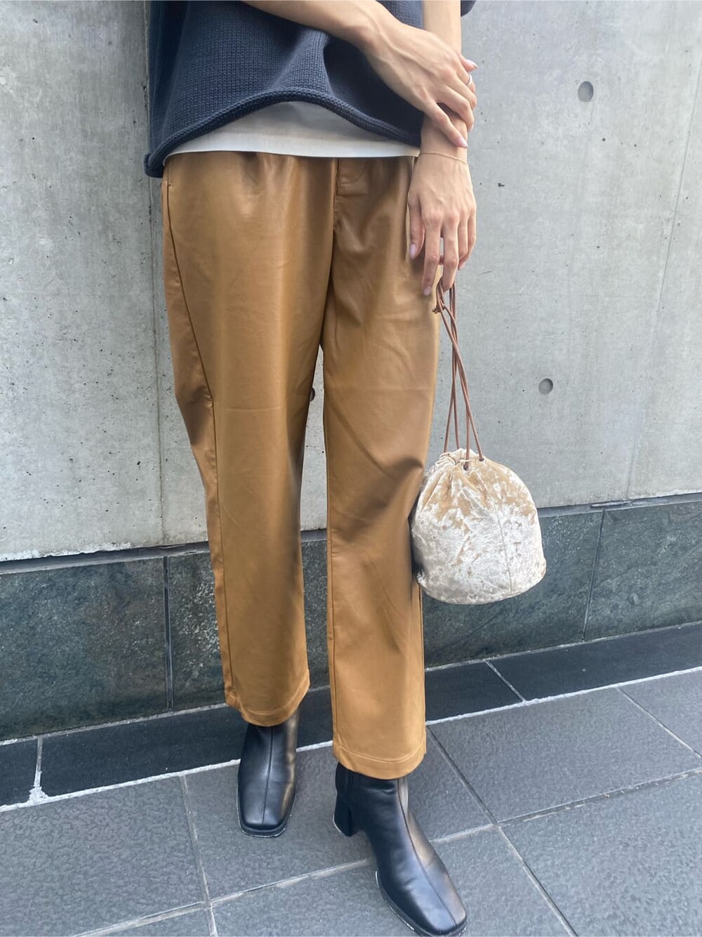 ブラウン系のその他パンツ、ブラック系のブーツ、ホワイト系のハンドバッグを着用したレディースの秋コーディネートの5枚目の写真