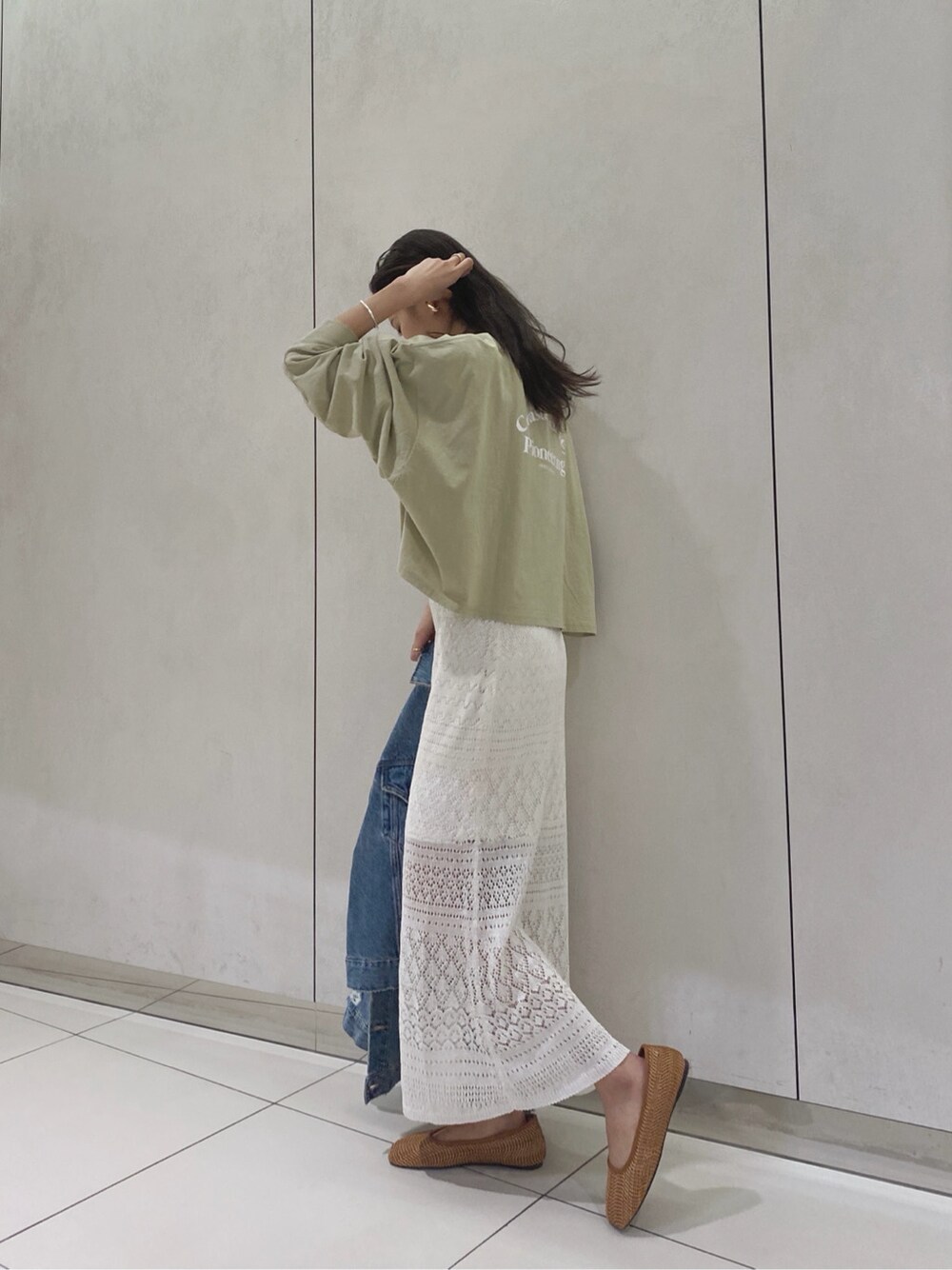 ブルー系のデニムジャケット、ホワイト系のスカート、ブラウン系のその他シューズを着用したレディースの春コーディネートの4枚目の写真