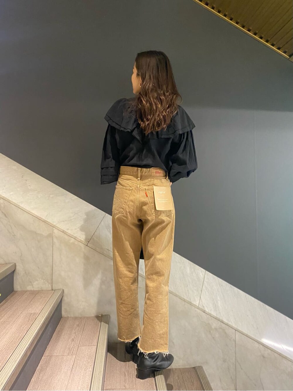 ブラック系のシャツ/ブラウス、ブラック系のハンドバッグ、ベージュ系のデニムパンツを着用したレディースの冬コーディネートの3枚目の写真