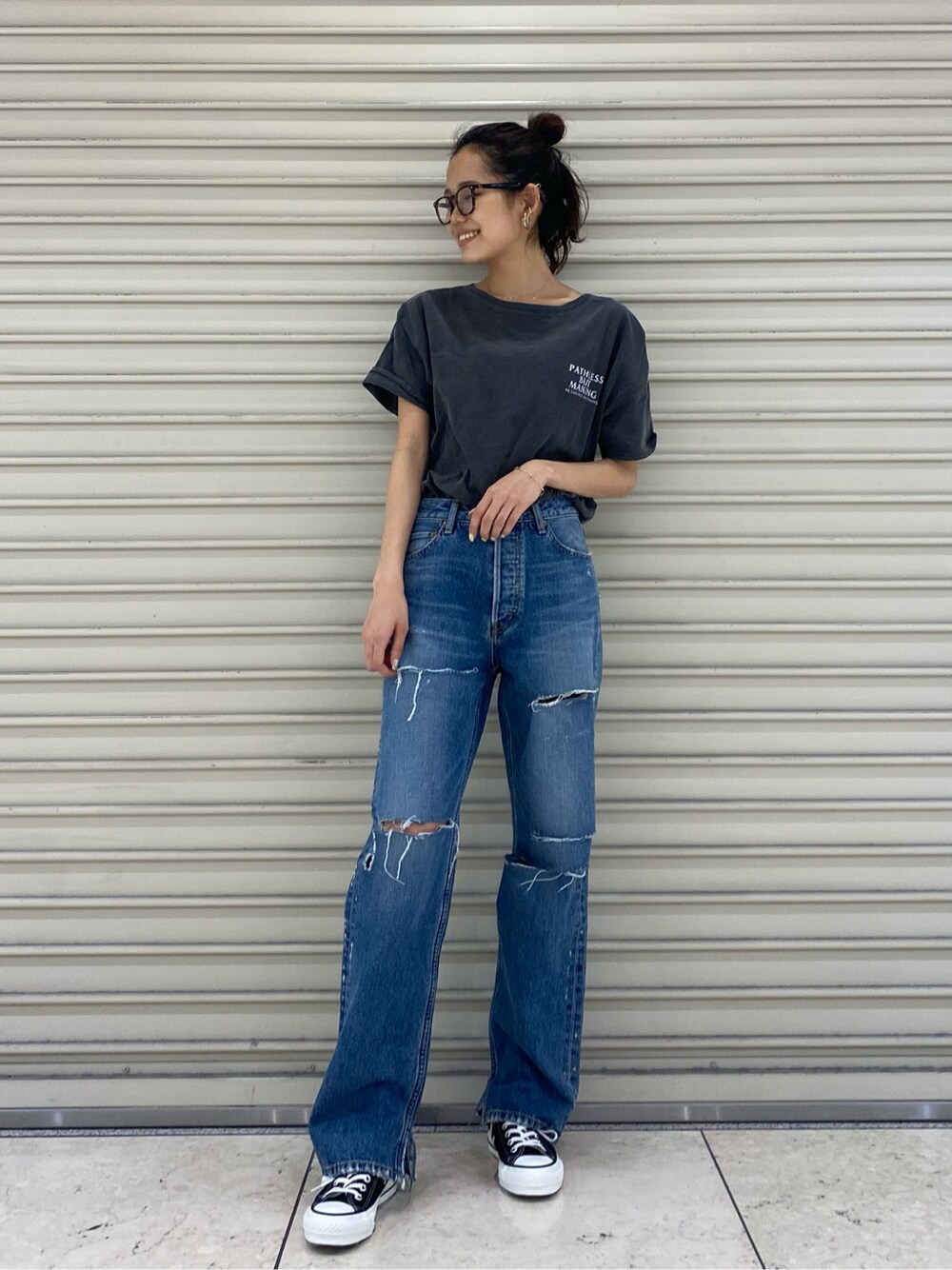 ブルー系のデニムパンツ、ゴールド系のブレスレット、ブラウン系のメガネを着用したレディースの春コーディネートの5枚目の写真