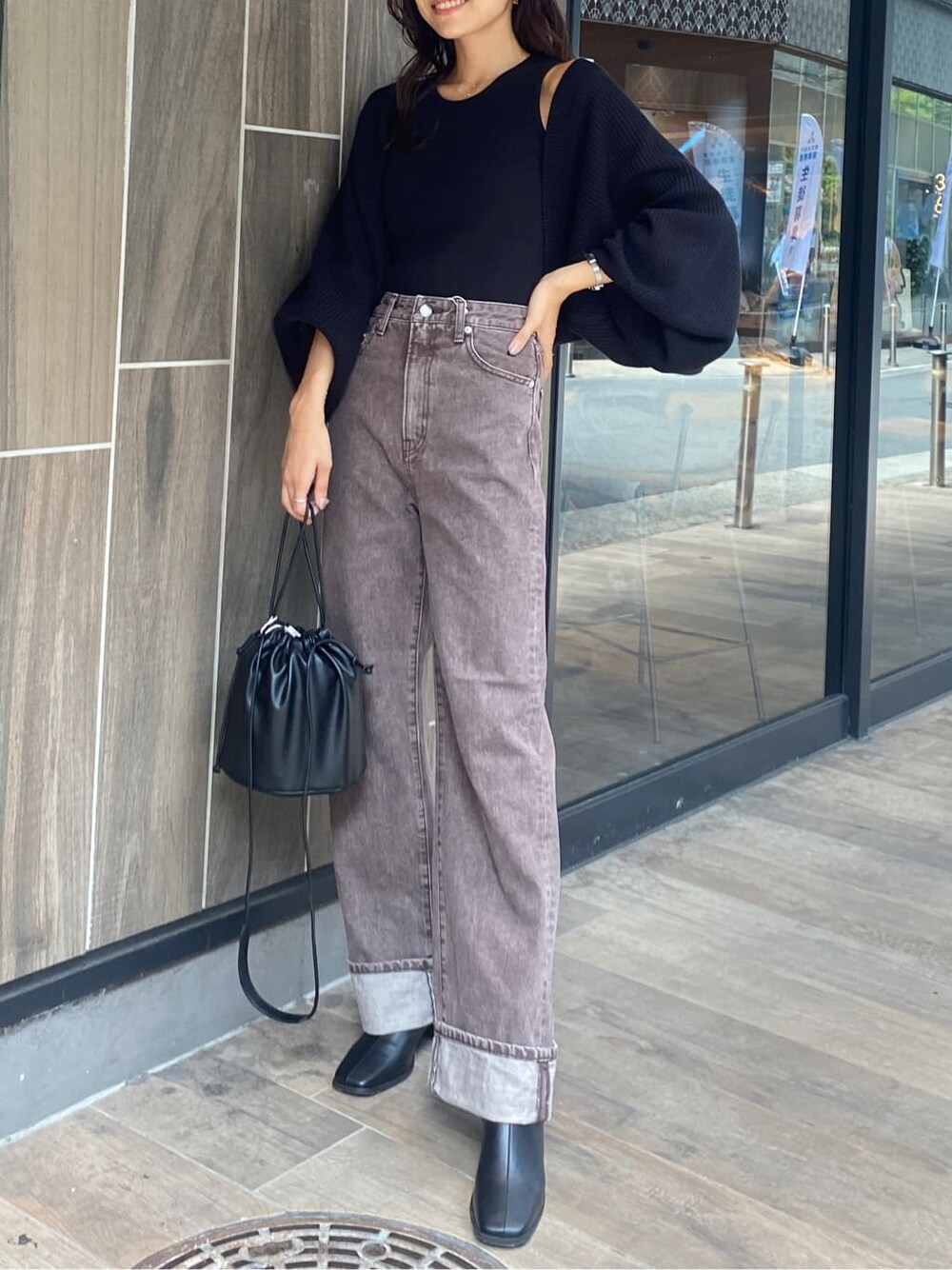 ブラック系のブーツ、ブラウン系のデニムパンツ、ブラック系のカーディガン/ボレロを着用したレディースの秋コーディネートの2枚目の写真