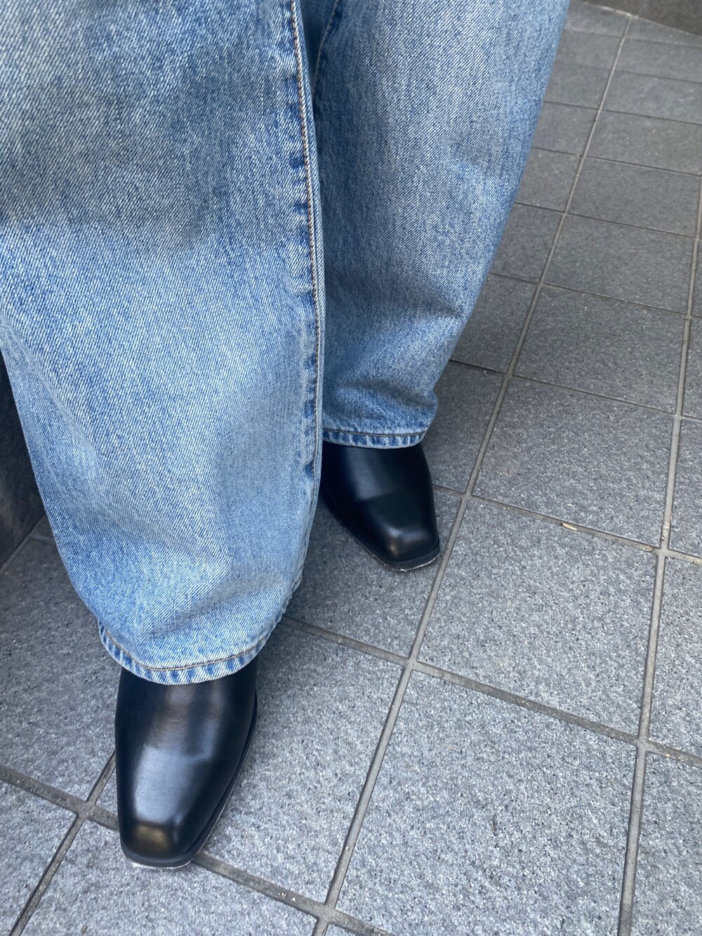 ホワイト系のニット/セーター、ブルー系のデニムパンツ、ブラック系のブーツを着用したレディースの秋コーディネートの7枚目の写真