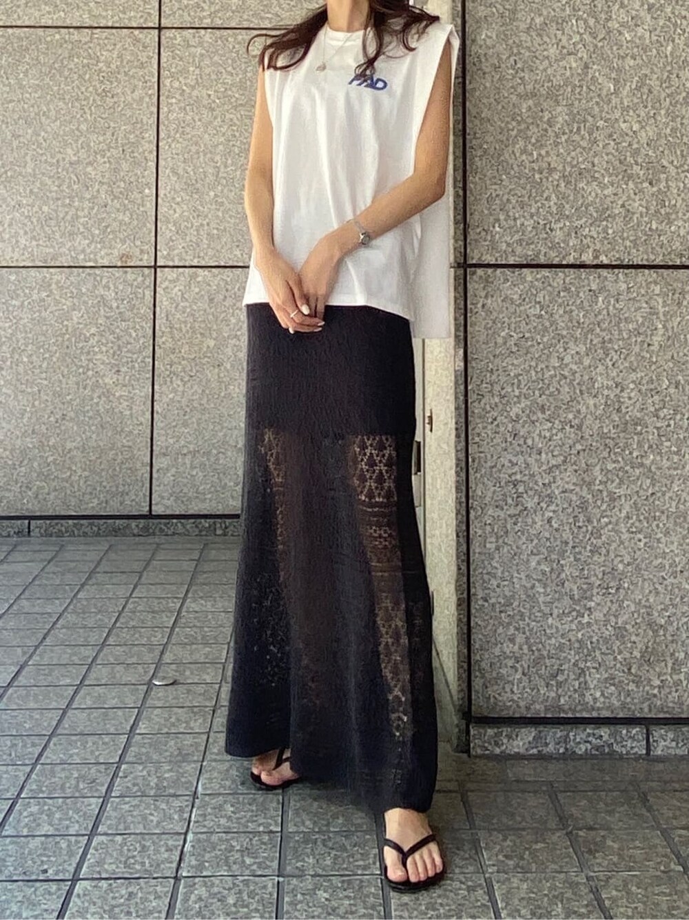 グレー系のスカート、ホワイト系のタンクトップ、シルバー系のネックレスを着用したレディースの春コーディネートの3枚目の写真