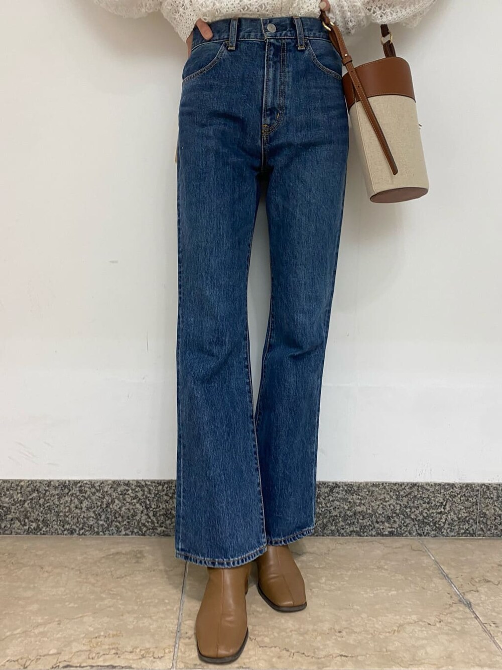 ブラウン系のショルダーバッグ、ブルー系のデニムパンツ、ホワイト系のシャツ/ブラウスを着用したレディースの春コーディネートの5枚目の写真