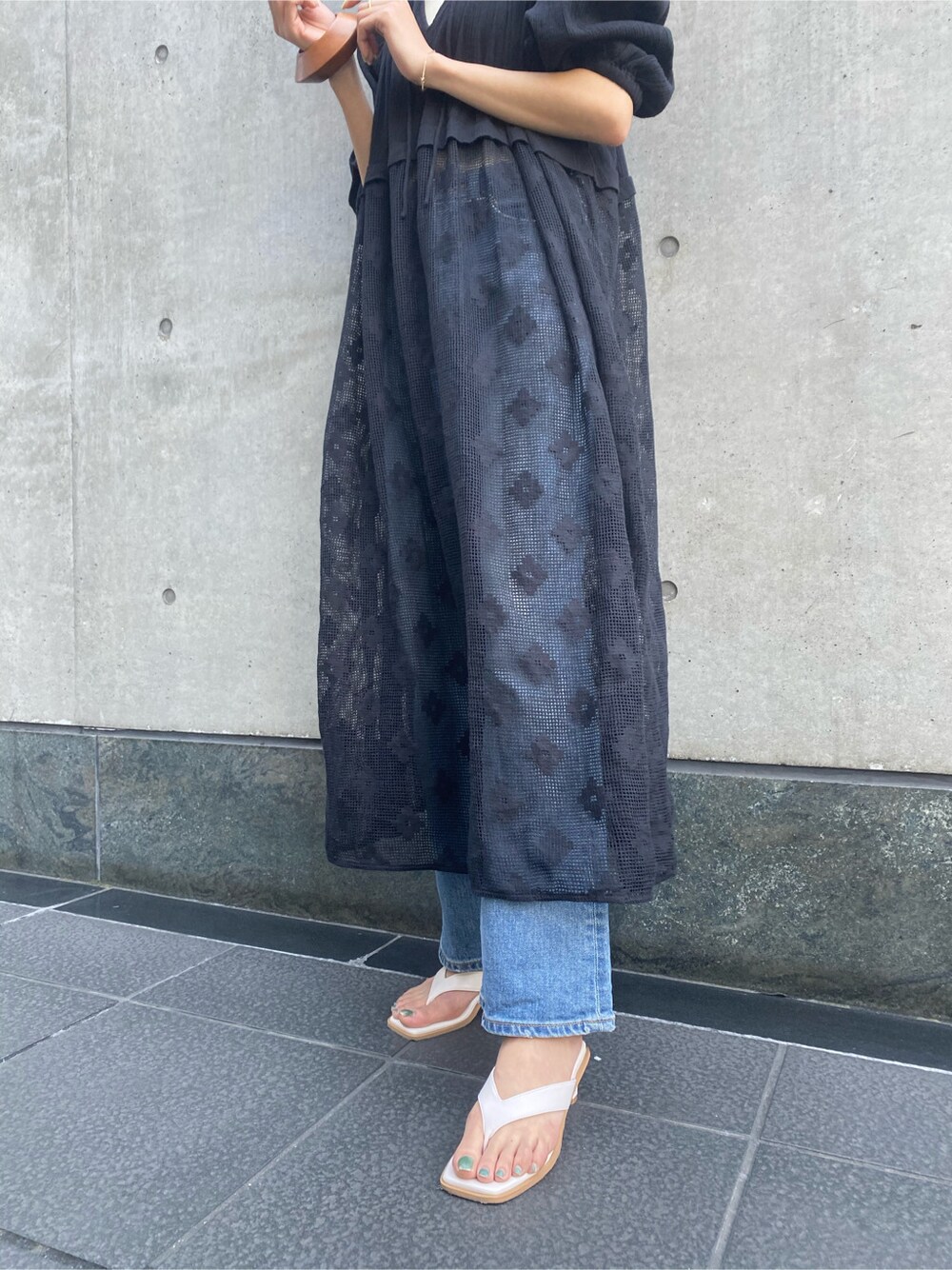 ホワイト系のサンダル、ブルー系のデニムパンツ、ベージュ系のバングル/リストバンドを着用したレディースの春コーディネートの3枚目の写真