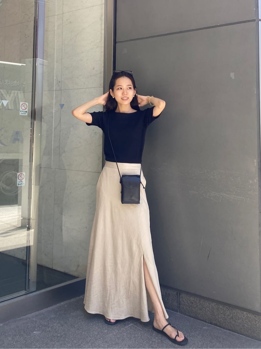 ベージュ系のスカート、ブラック系のTシャツ/カットソーを着用したレディースの夏コーディネートの2枚目の写真