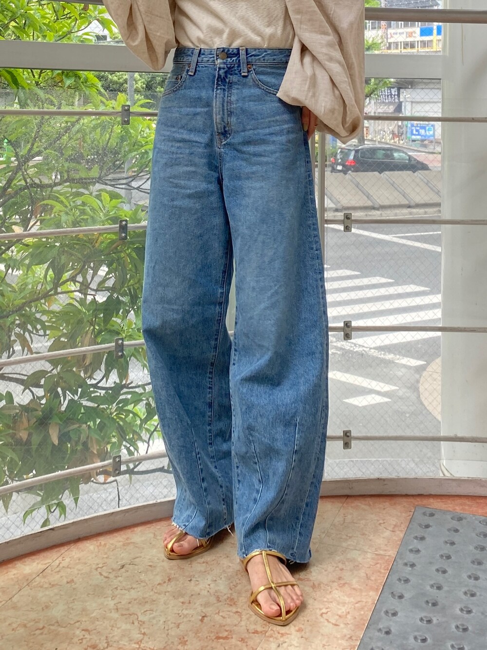 ベージュ系のシャツ/ブラウス、ブルー系のデニムパンツ、ゴールド系のサンダルを着用したレディースの春コーディネートの5枚目の写真