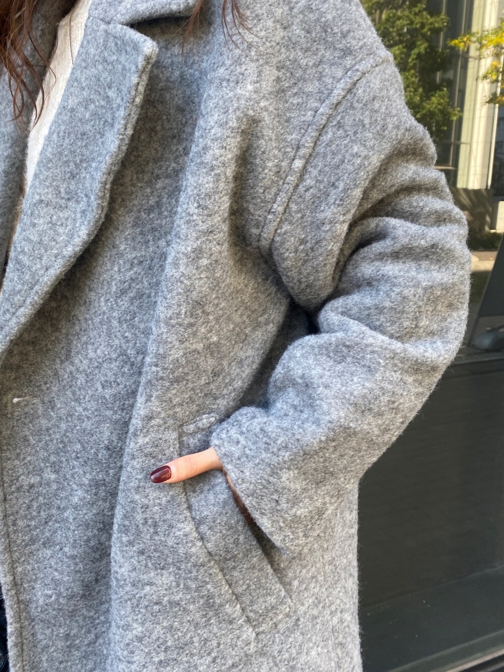 ホワイト系のニット/セーター、グレー系のチェスターコート、ブルー系のデニムパンツを着用したレディースの秋コーディネートの5枚目の写真