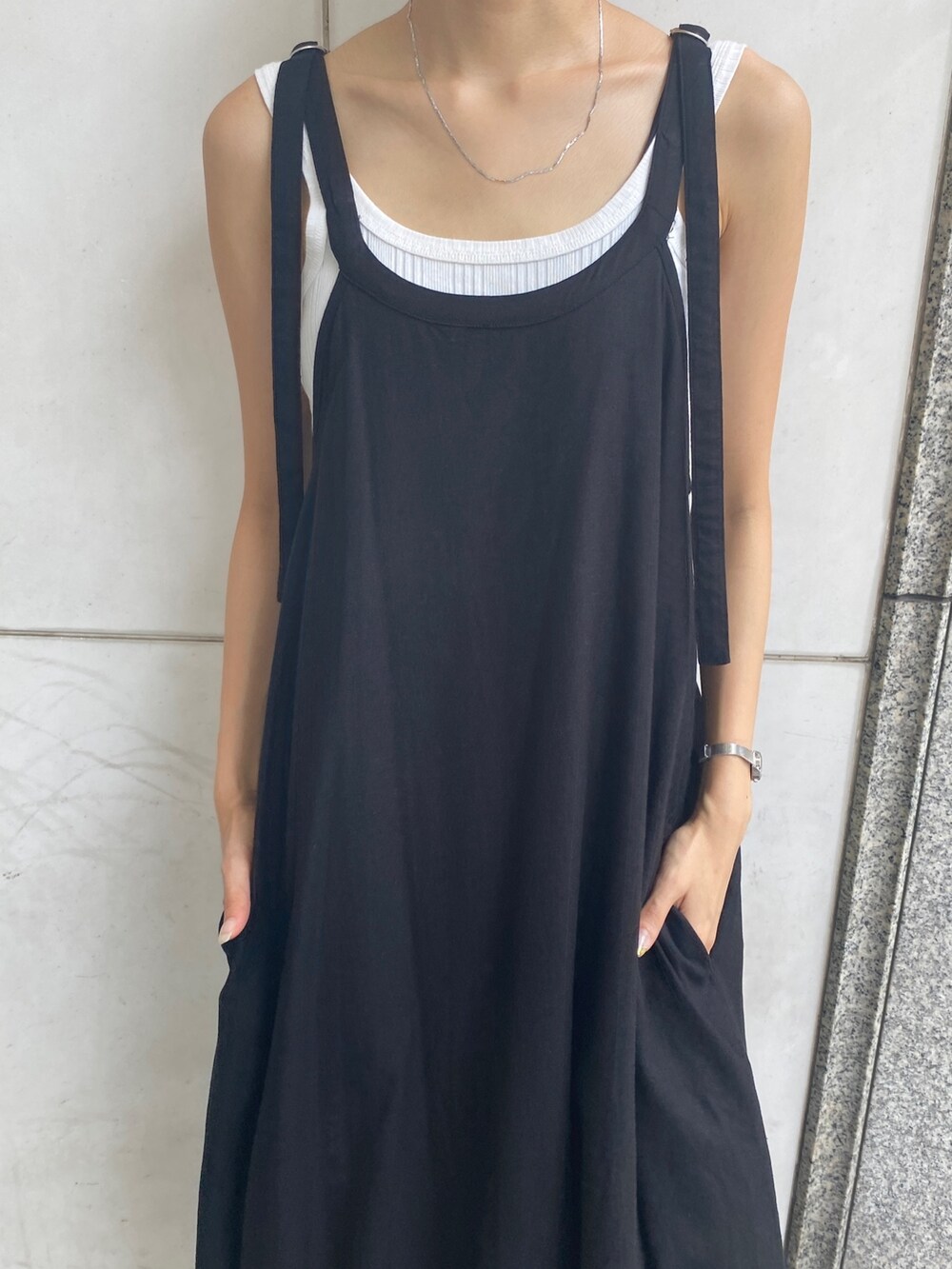 ブラック系のワンピース、ホワイト系のタンクトップ、ブルー系のデニムパンツを着用したレディースの夏コーディネートの4枚目の写真