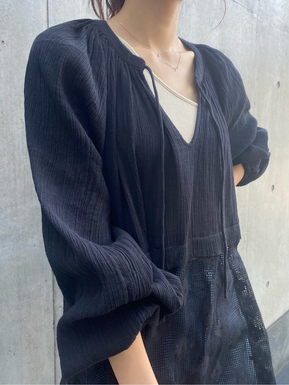 ホワイト系のサンダル、ブルー系のデニムパンツ、ベージュ系のバングル/リストバンドを着用したレディースの春コーディネートの2枚目の写真