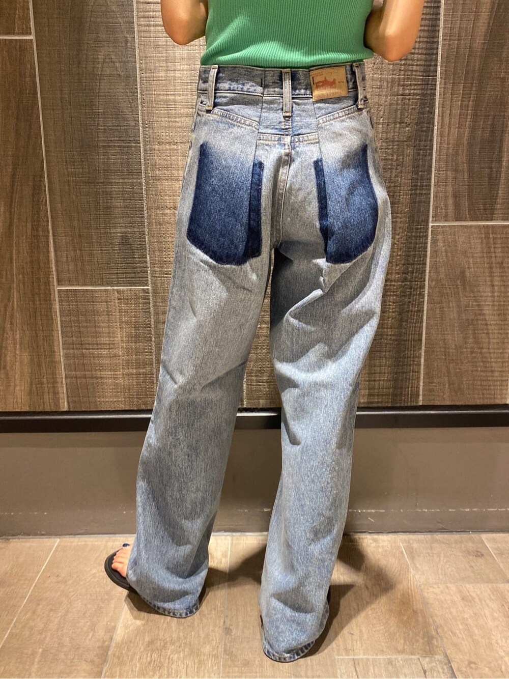 グリーン系のタンクトップ、ブルー系のデニムパンツを着用したレディースの夏コーディネートの8枚目の写真