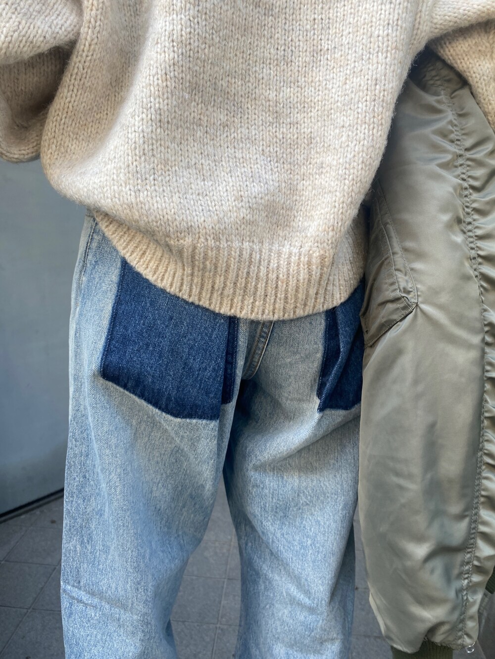 ホワイト系のニット/セーター、ブルー系のデニムパンツ、ブラック系のブーツを着用したレディースの秋コーディネートの9枚目の写真