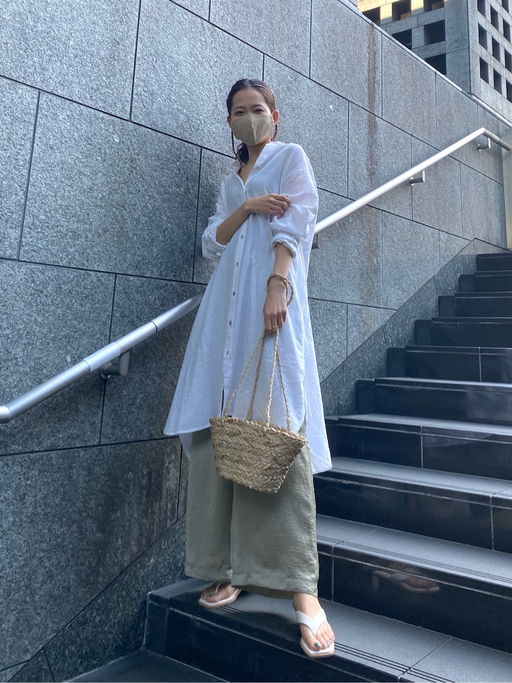 ホワイト系のサンダル、ベージュ系のかごバッグ、ホワイト系のワンピースを着用したレディースの春コーディネートの2枚目の写真