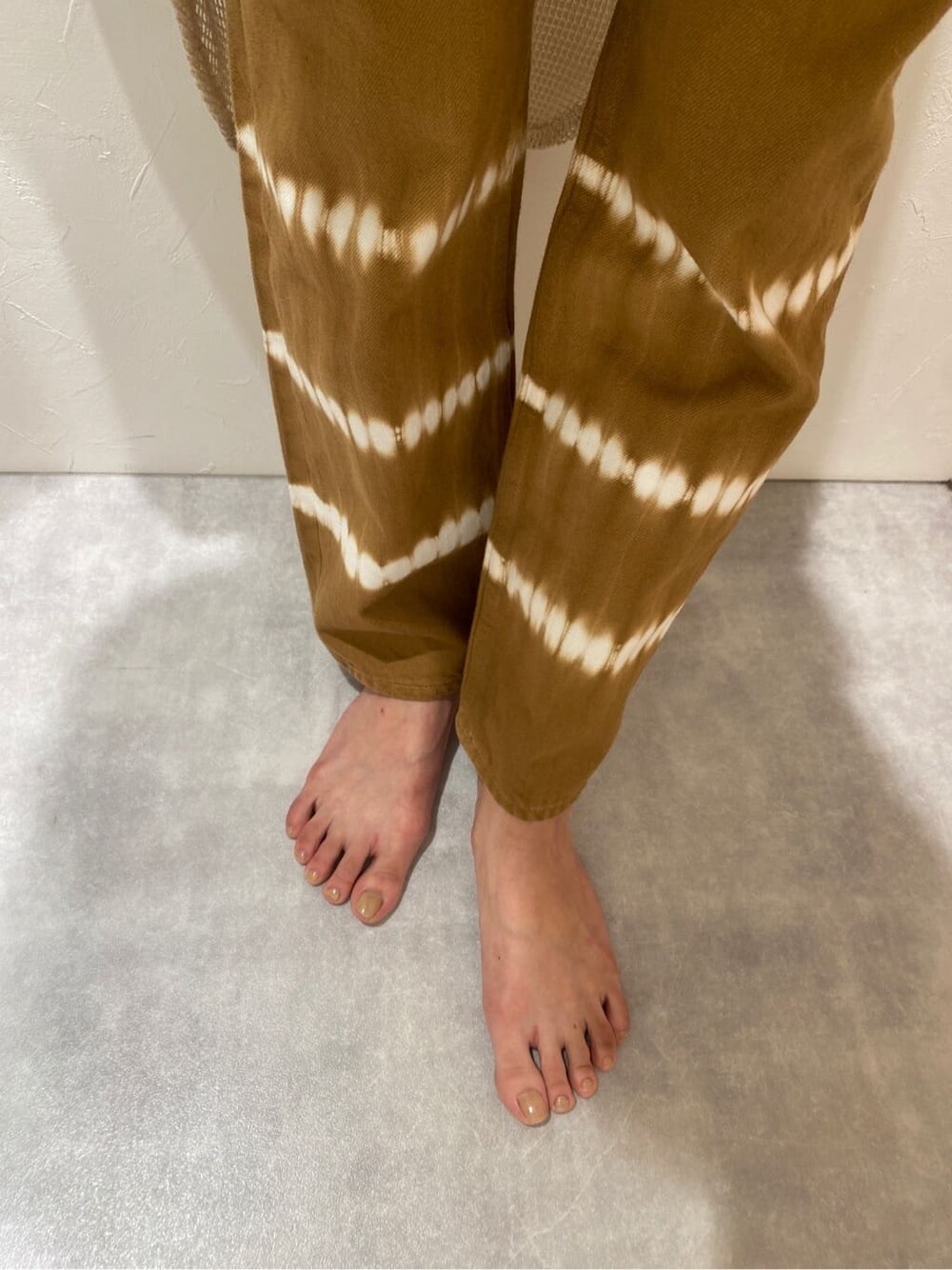 ホワイト系のワンピース、ブラウン系のデニムパンツを着用したレディースの春コーディネートの6枚目の写真