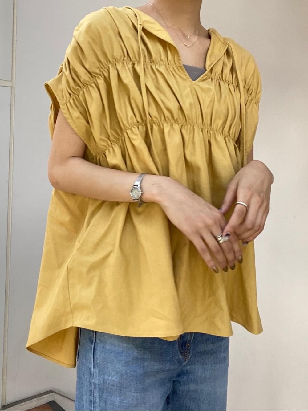 ブルー系のデニムパンツ、イエロー系のシャツ/ブラウスを着用したレディースの夏コーディネートの2枚目の写真