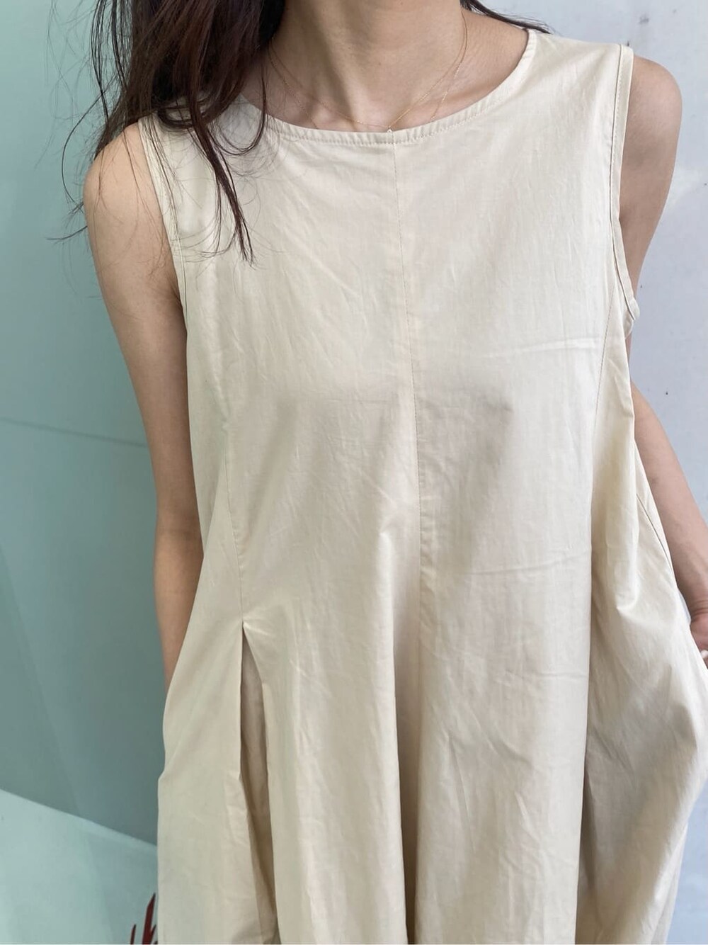 ブルー系のデニムパンツ、ベージュ系のワンピースを着用したレディースの春コーディネートの6枚目の写真