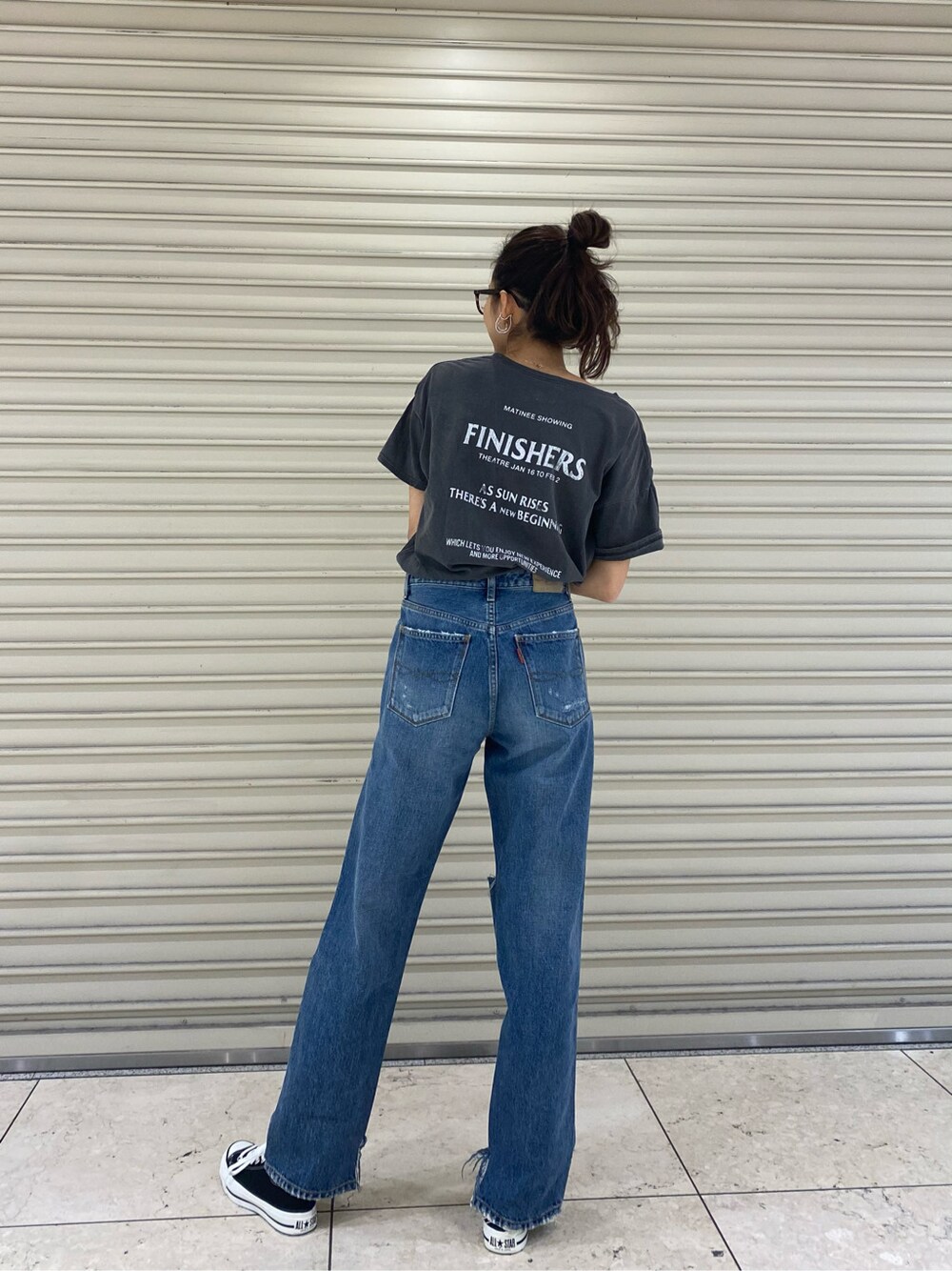 ブルー系のデニムパンツ、ゴールド系のブレスレット、ブラウン系のメガネを着用したレディースの春コーディネートの4枚目の写真