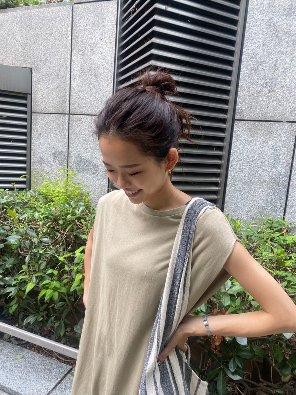 ブラック系のサンダル、ベージュ系のワンピース、ブルー系のデニムパンツを着用したレディースの夏コーディネートの4枚目の写真