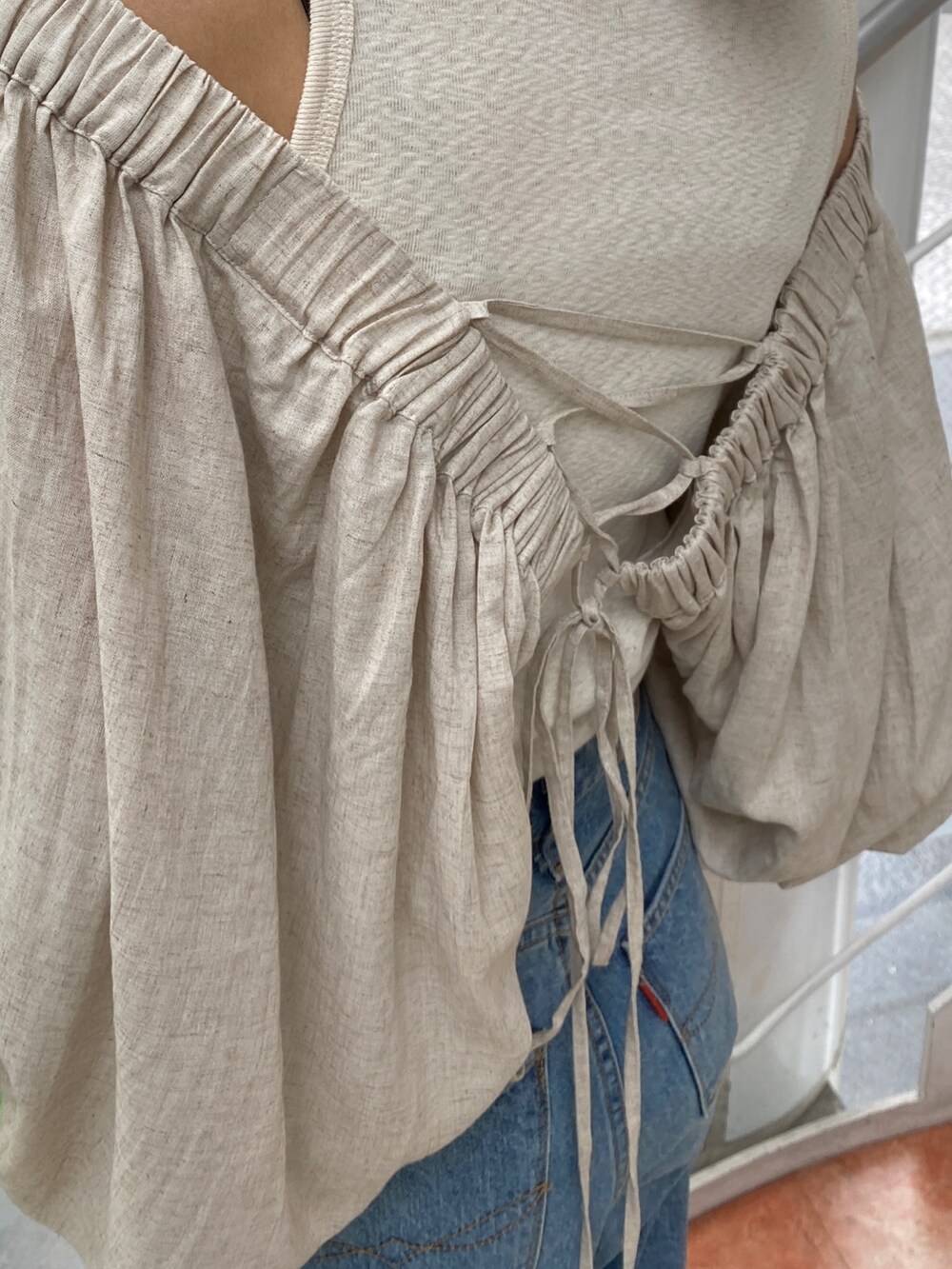 ベージュ系のシャツ/ブラウス、ブルー系のデニムパンツ、ゴールド系のサンダルを着用したレディースの春コーディネートの4枚目の写真