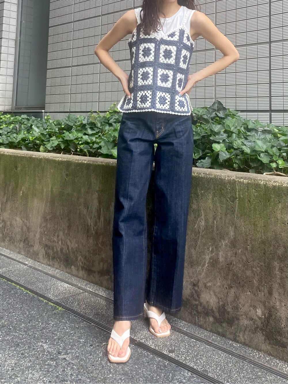 ホワイト系のタンクトップ、ブルー系のデニムパンツを着用したレディースの夏コーディネートの2枚目の写真