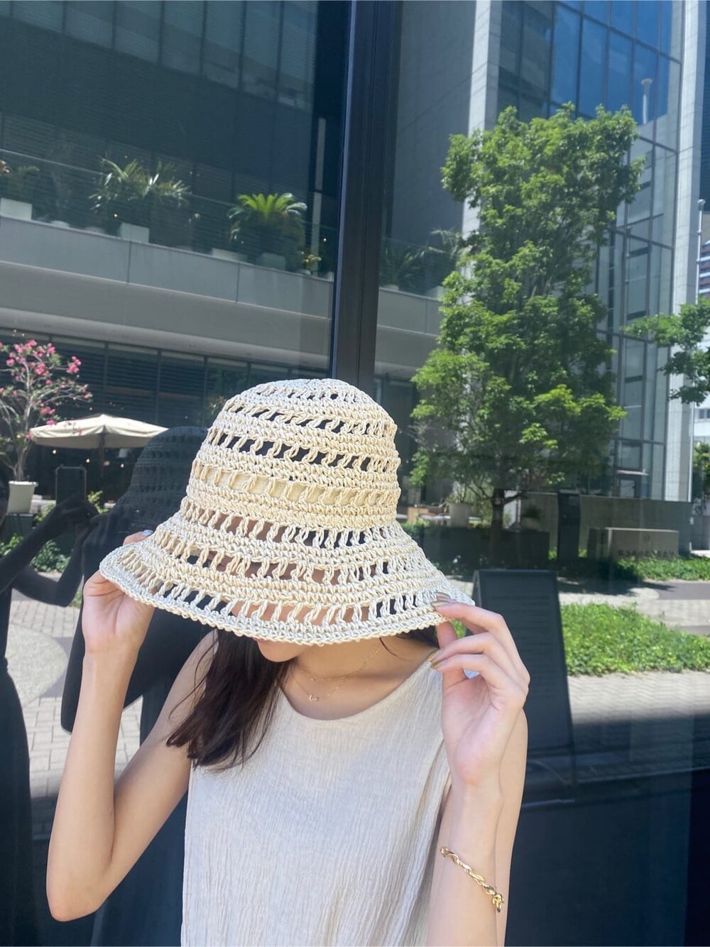 ブラック系のサンダル、ホワイト系のワンピース、ベージュ系のハットを着用したレディースの夏コーディネートの7枚目の写真